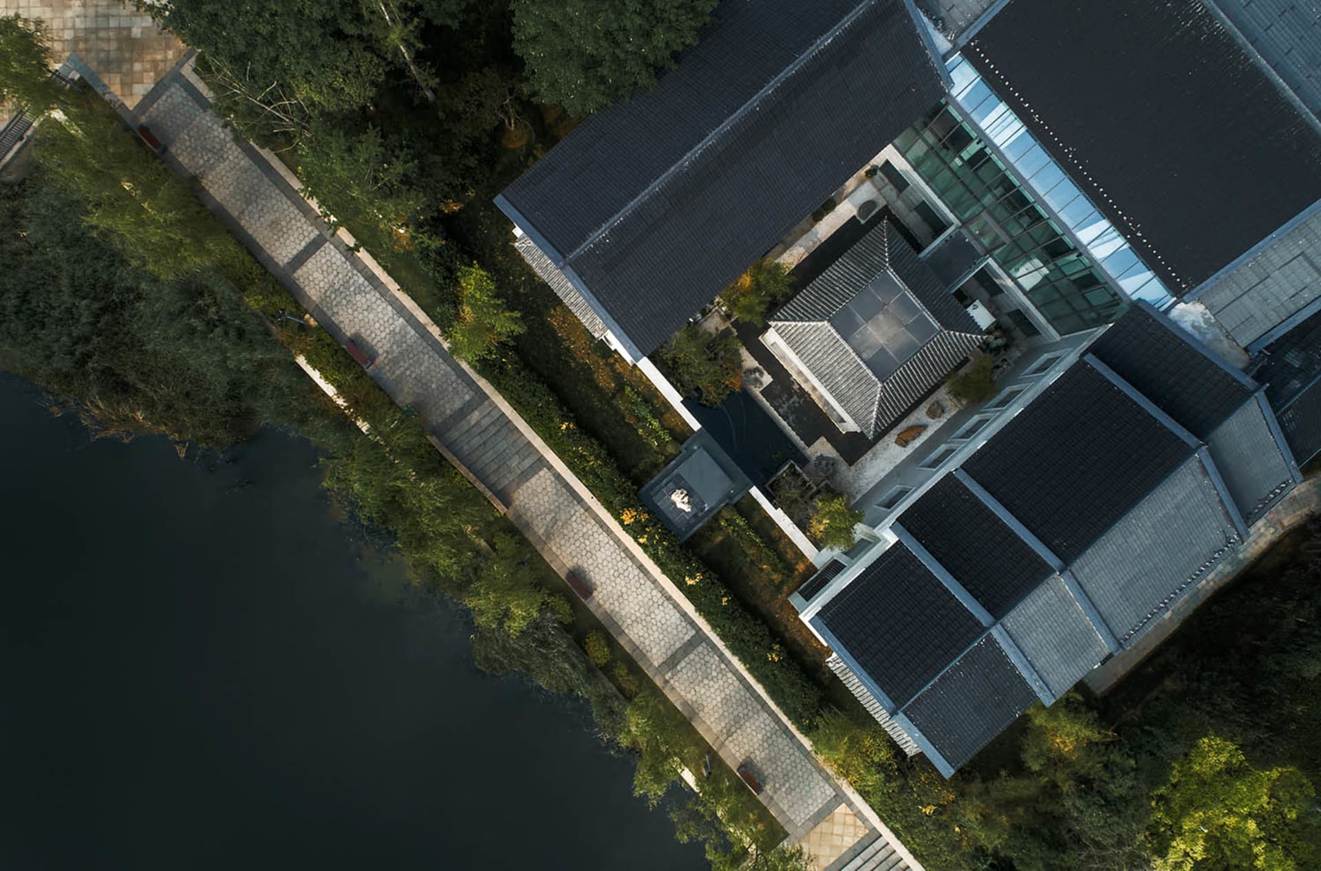 Modern residential building surrounded by nature with luxury stone, glass, and wooden features.