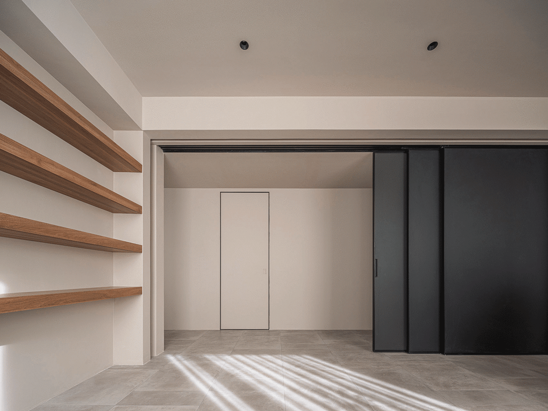 A minimalist living room features wooden shelves and concrete flooring.