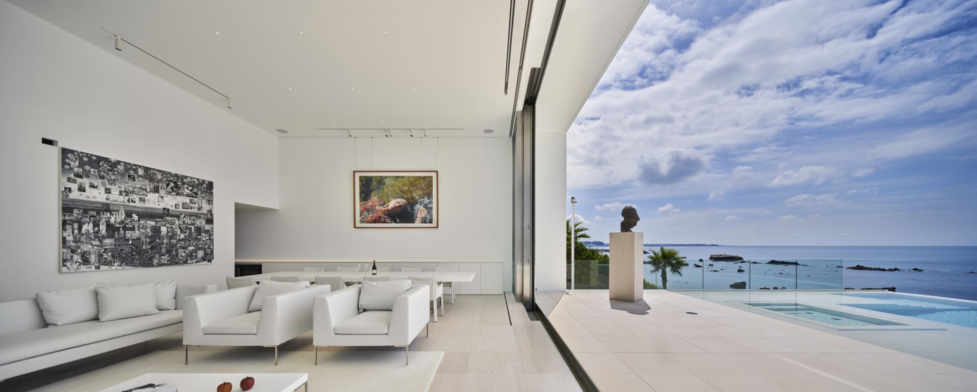 A modern living room featuring a glass ceiling and panoramic ocean view.