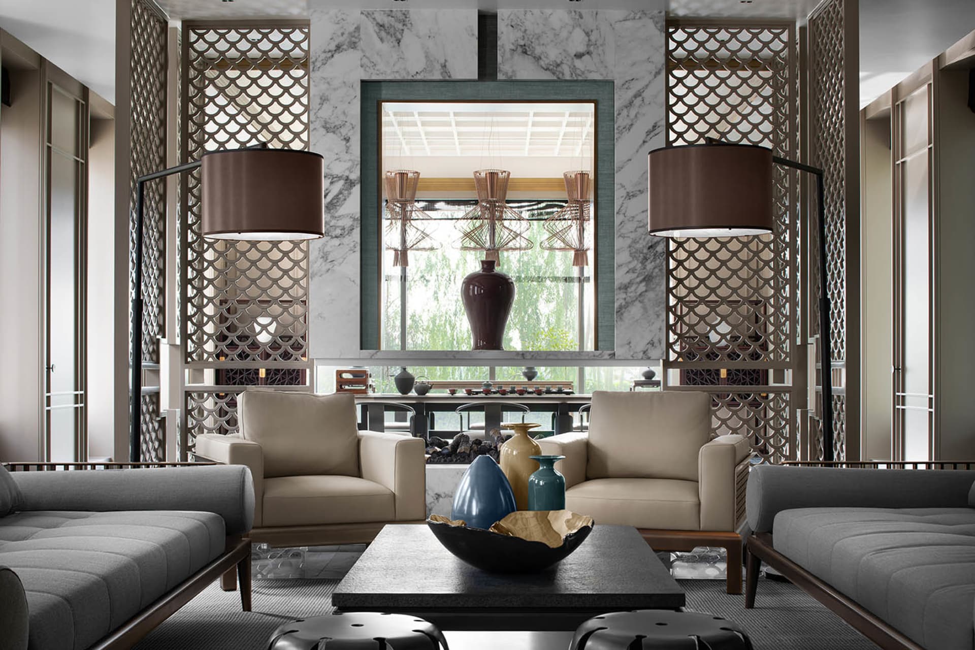 Modern living room with marble fireplace, leather chairs, and glass vases.