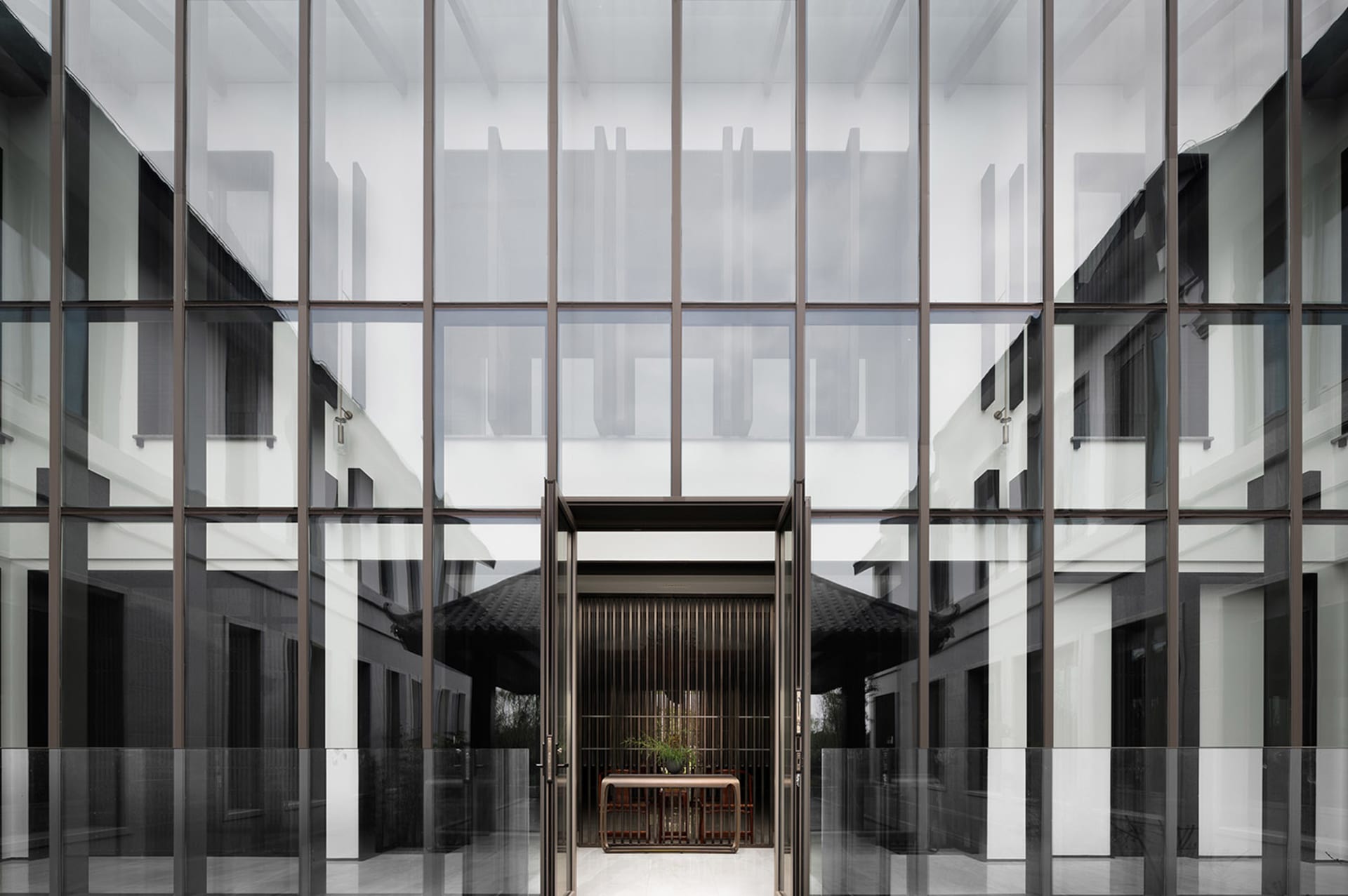 Modern, glass-enclosed lobby with lighting.