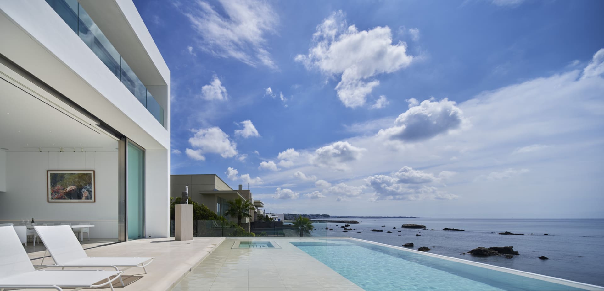 Modern vacation home with a glass and concrete floor overlooking the ocean.