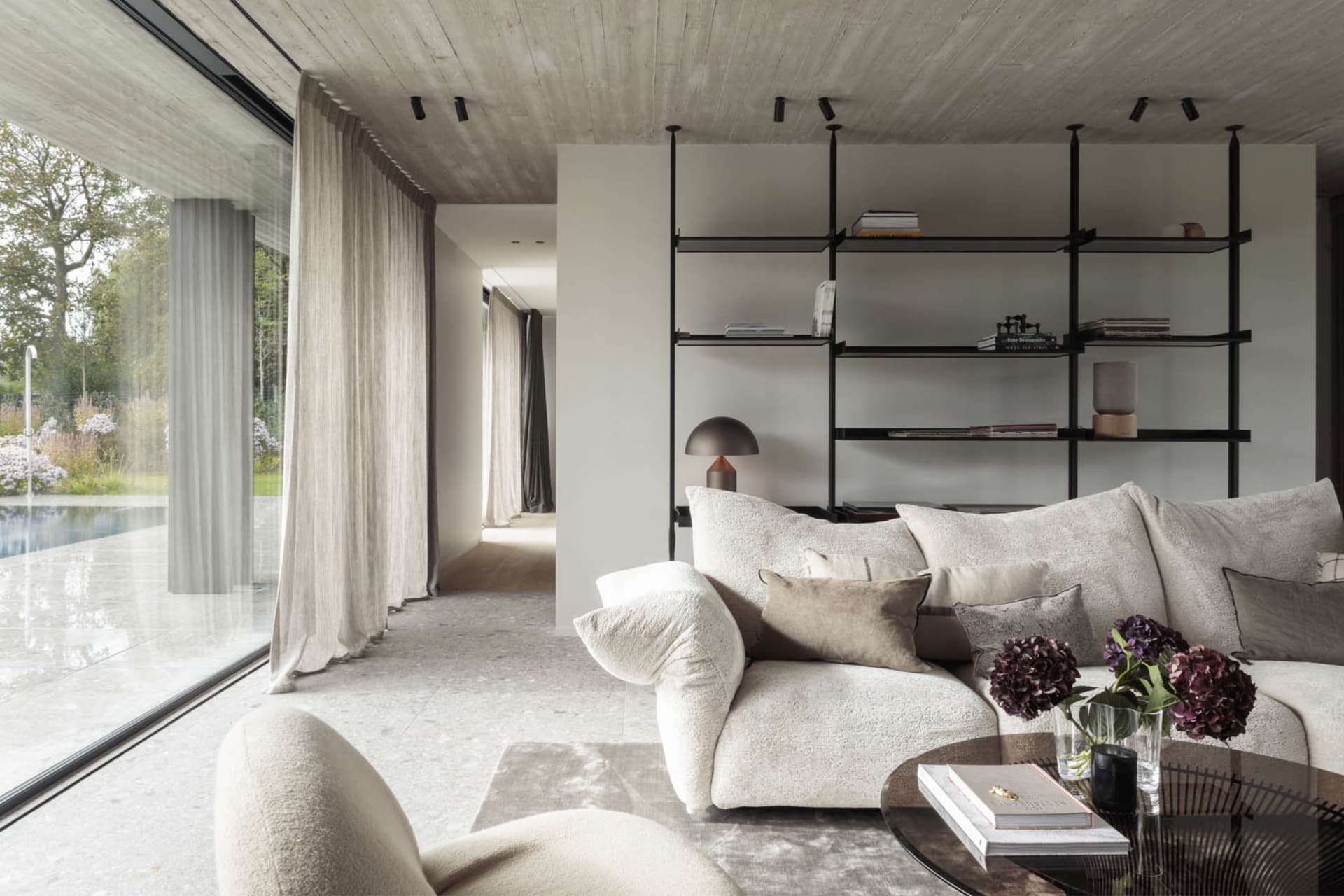 A modern living room featuring concrete elements and plush textiles.