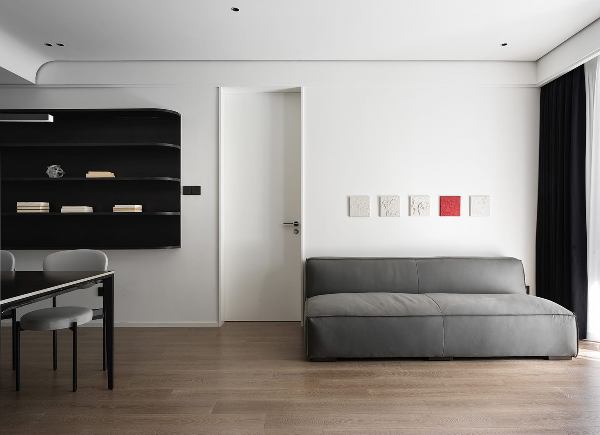 Modern living room featuring sleek leather furniture, wooden flooring, and glass accents.