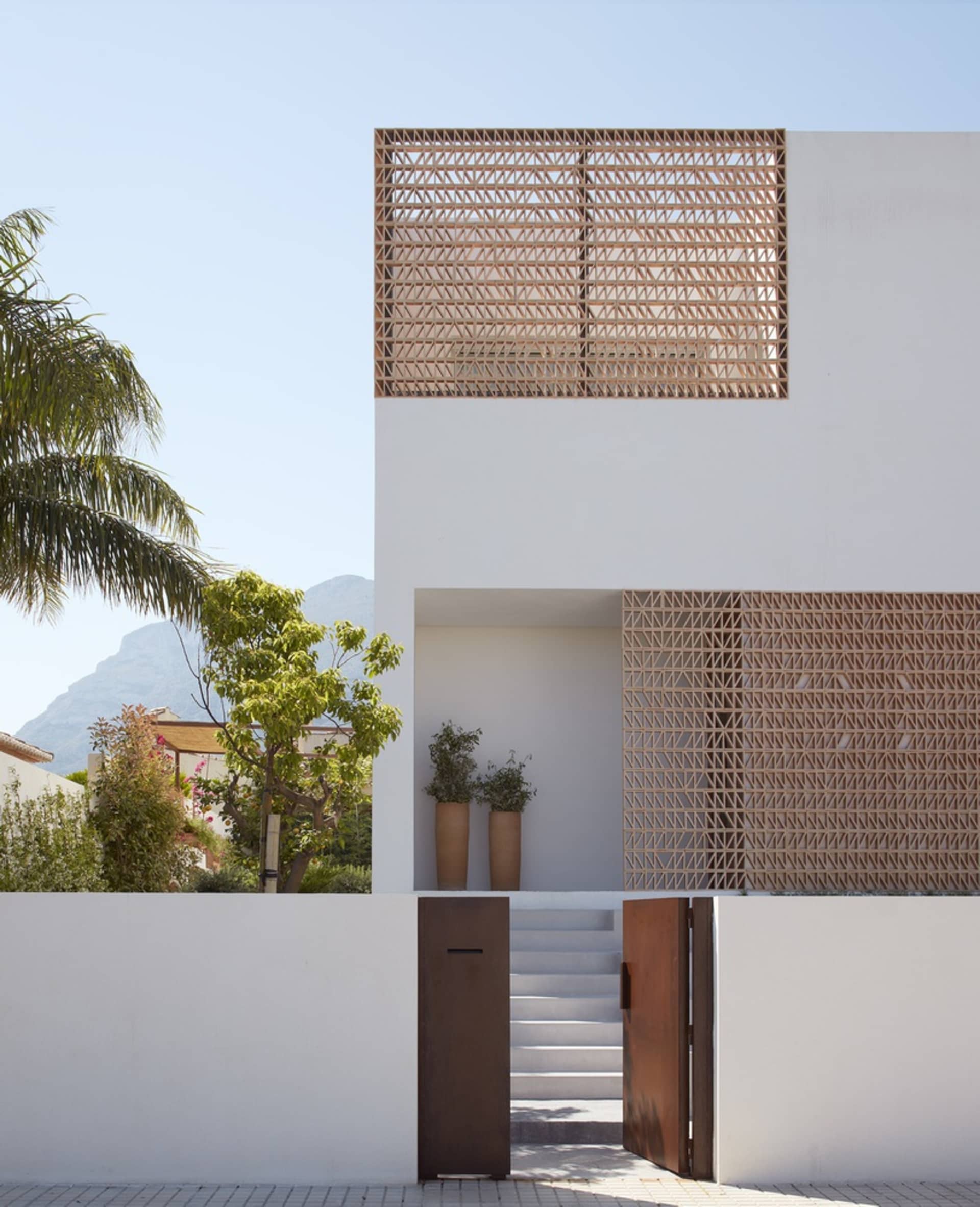 Modern minimalist residential house with concrete exterior and wooden elements.