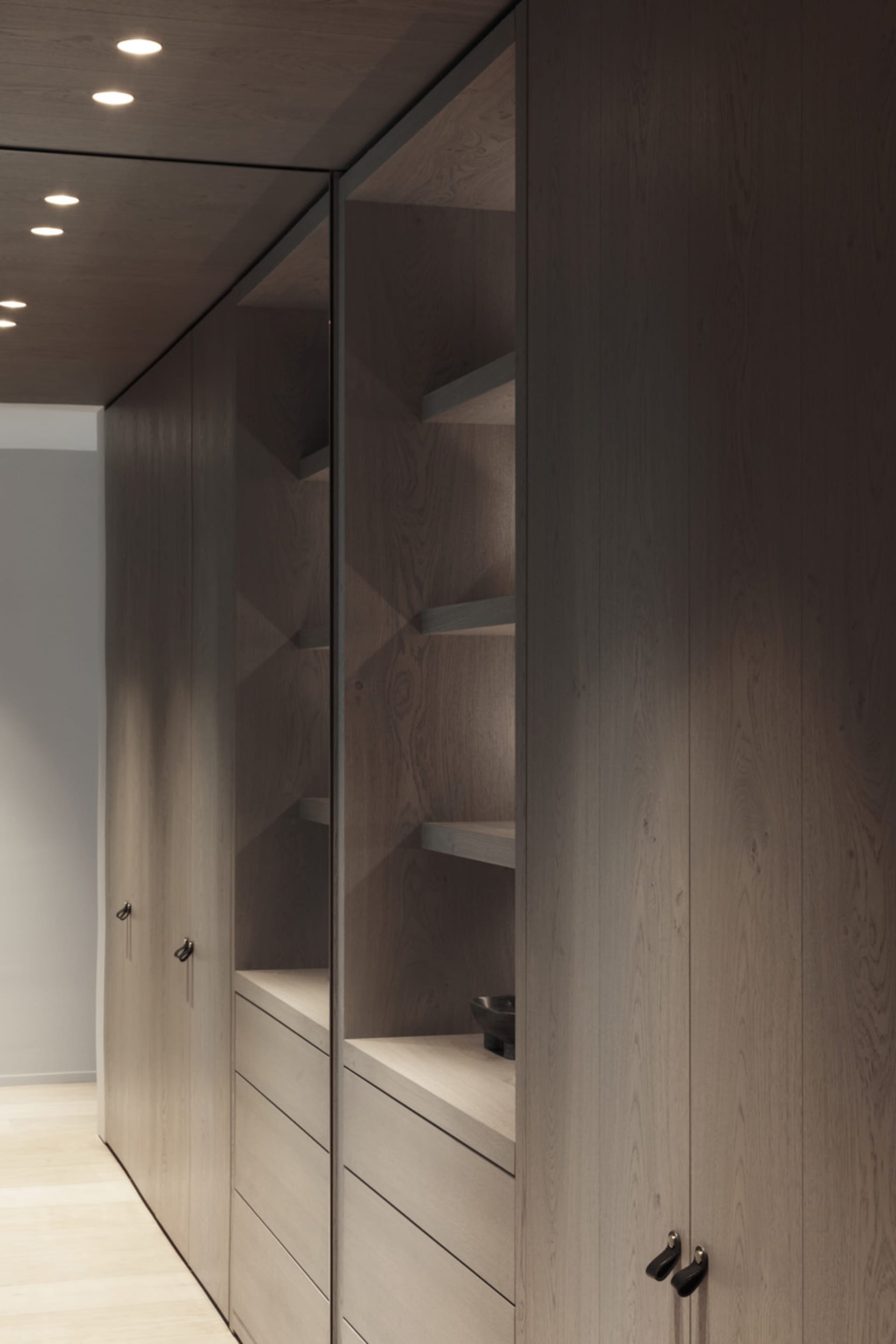 Modern wardrobe with wooden cabinets and built-in shelves.