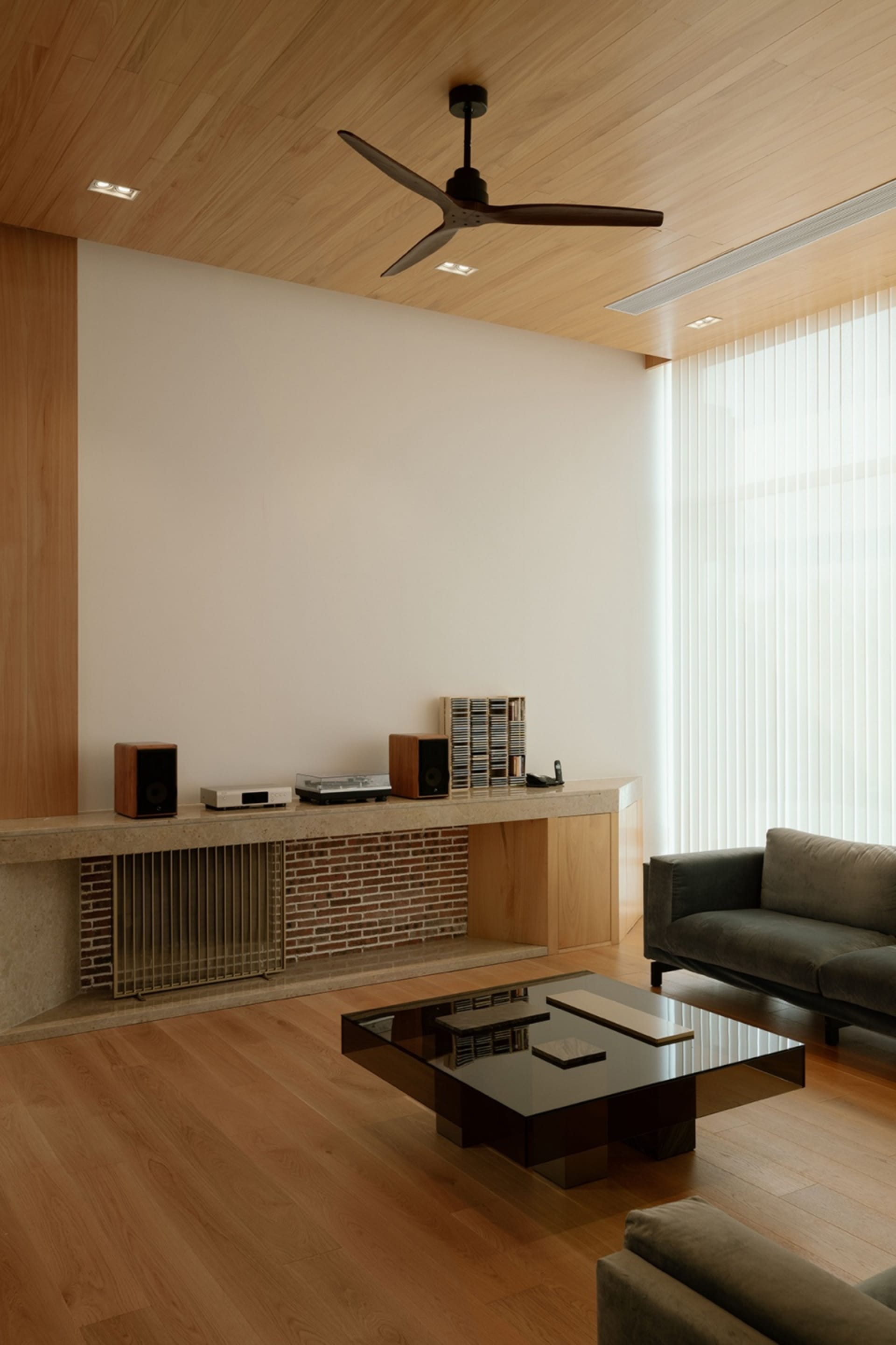 Minimalist modern living room featuring wood and brick materials