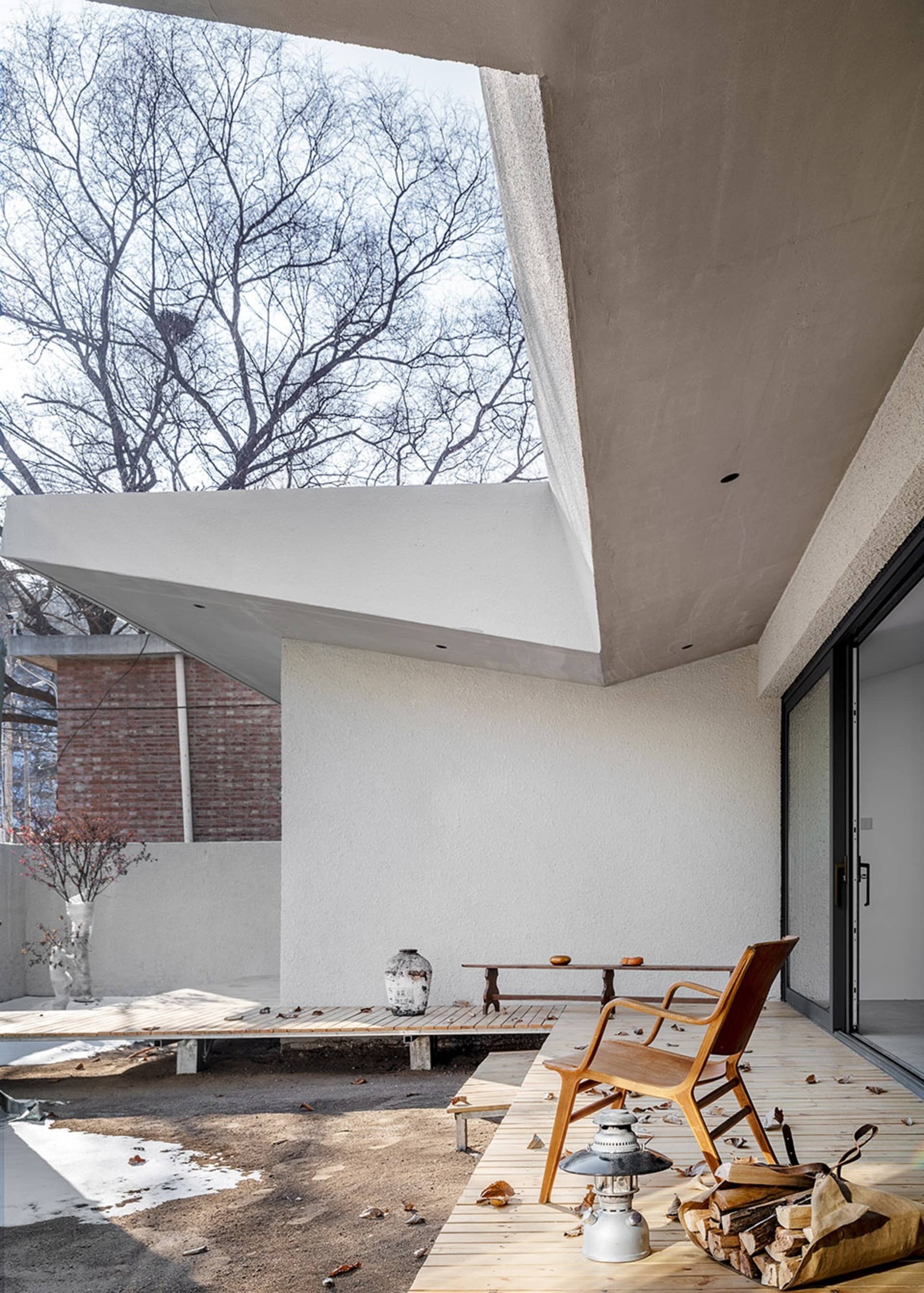 Modern terrace with glass walls, concrete ceiling, and wooden flooring.