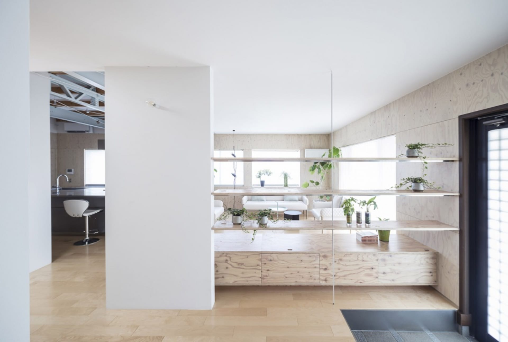 A minimalist living room featuring wooden elements and plants.