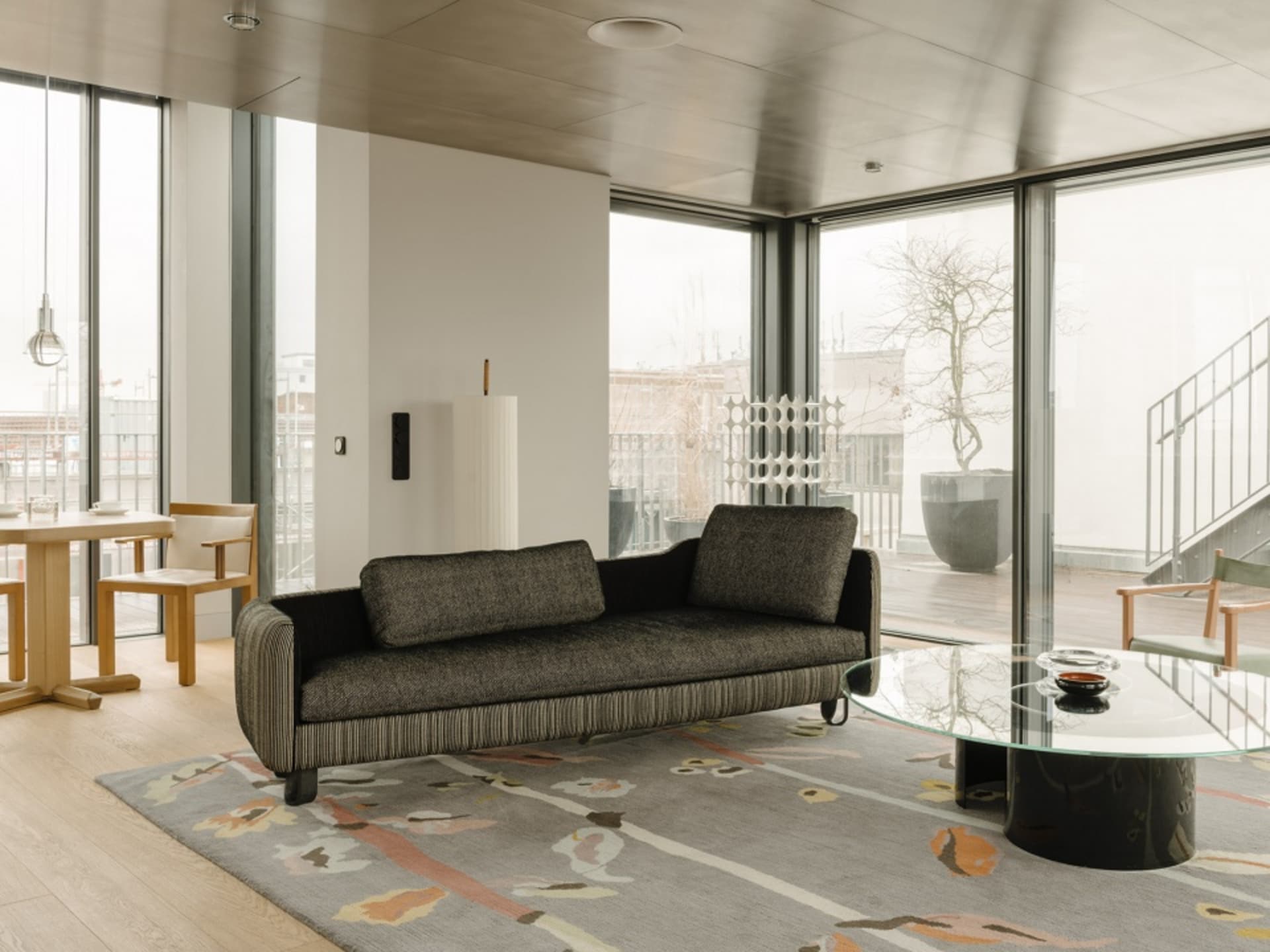 Modern living room featuring contemporary furniture with mixed materials and a stylish rug.