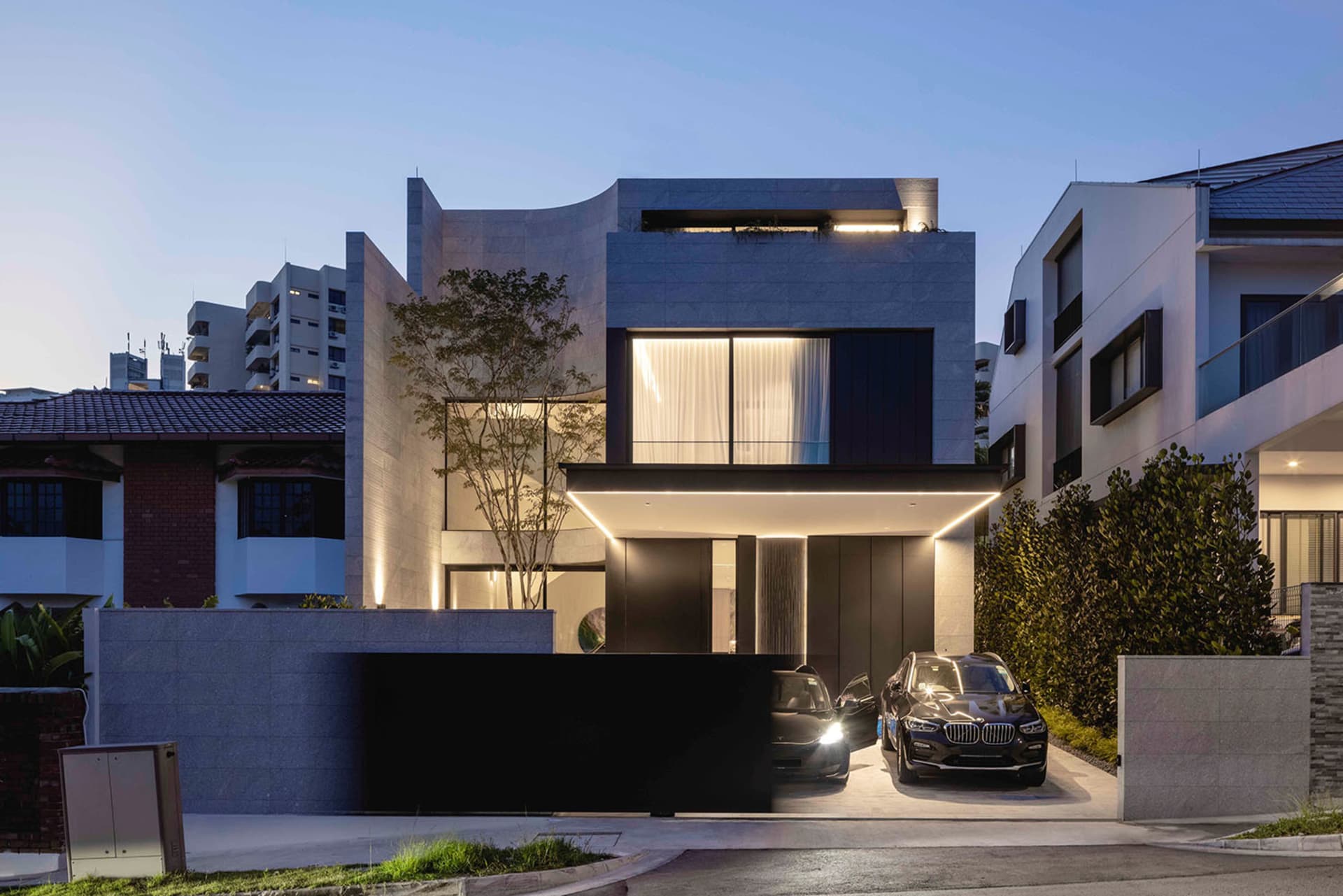 Modern residential building with concrete exterior and illuminated windows.