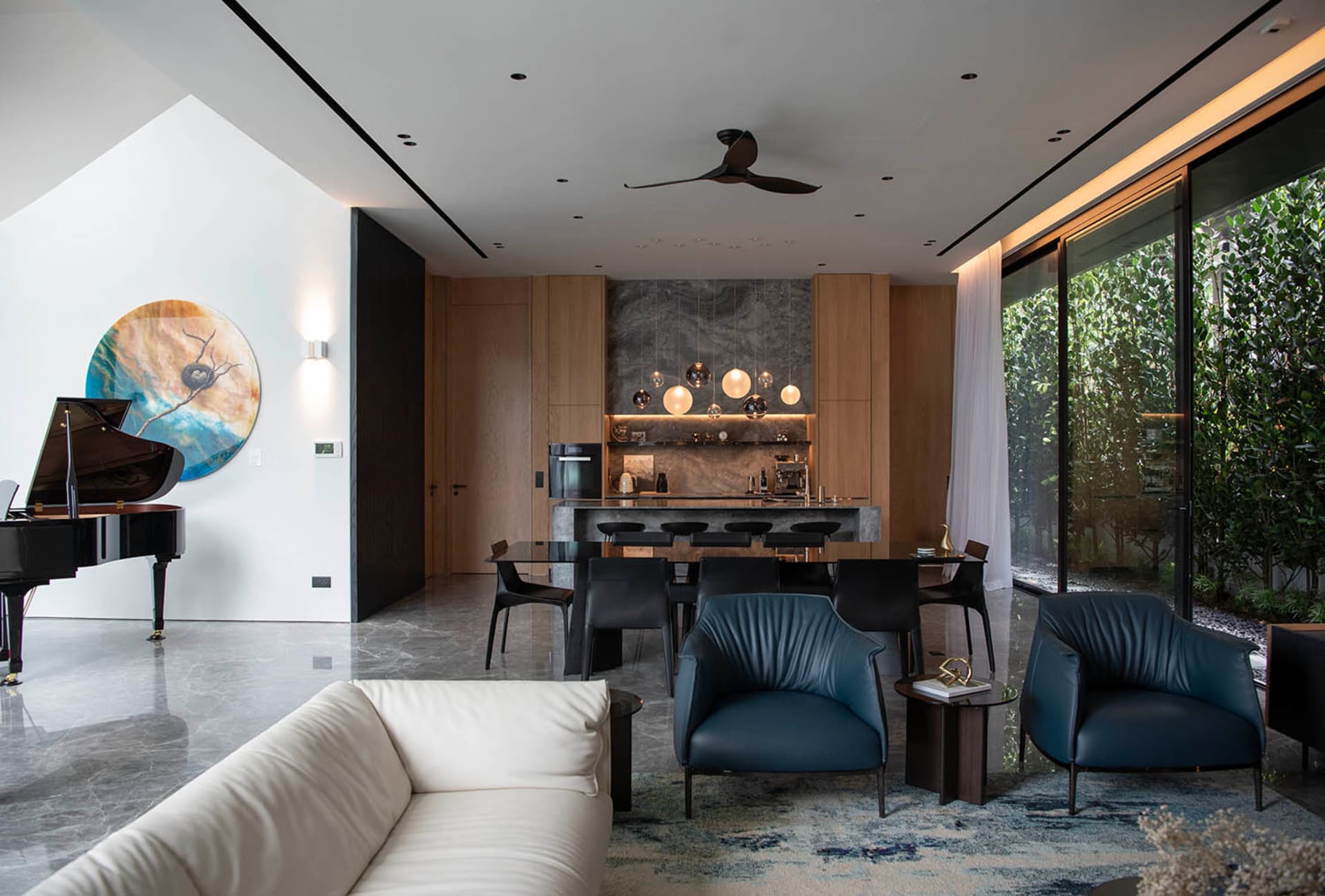 Modern living and dining area with marble flooring, indoor plants, and a mix of materials.