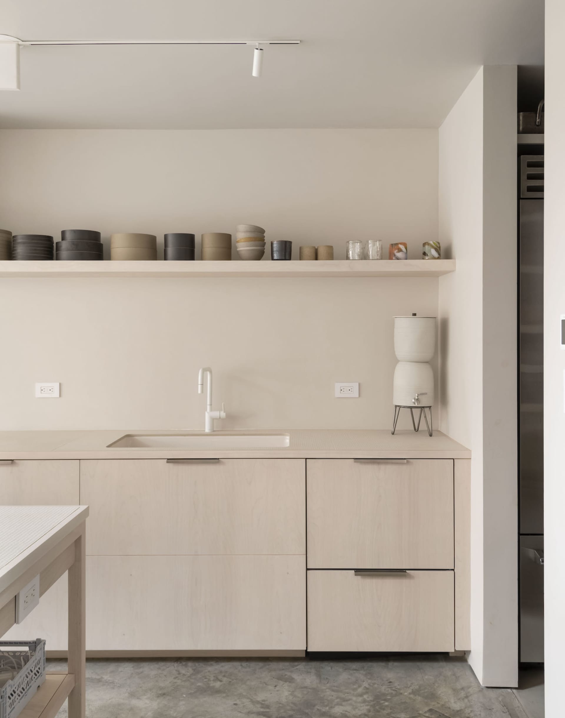 Minimalist kitchen interior with light wood cabinets and sleek, modern fixtures.