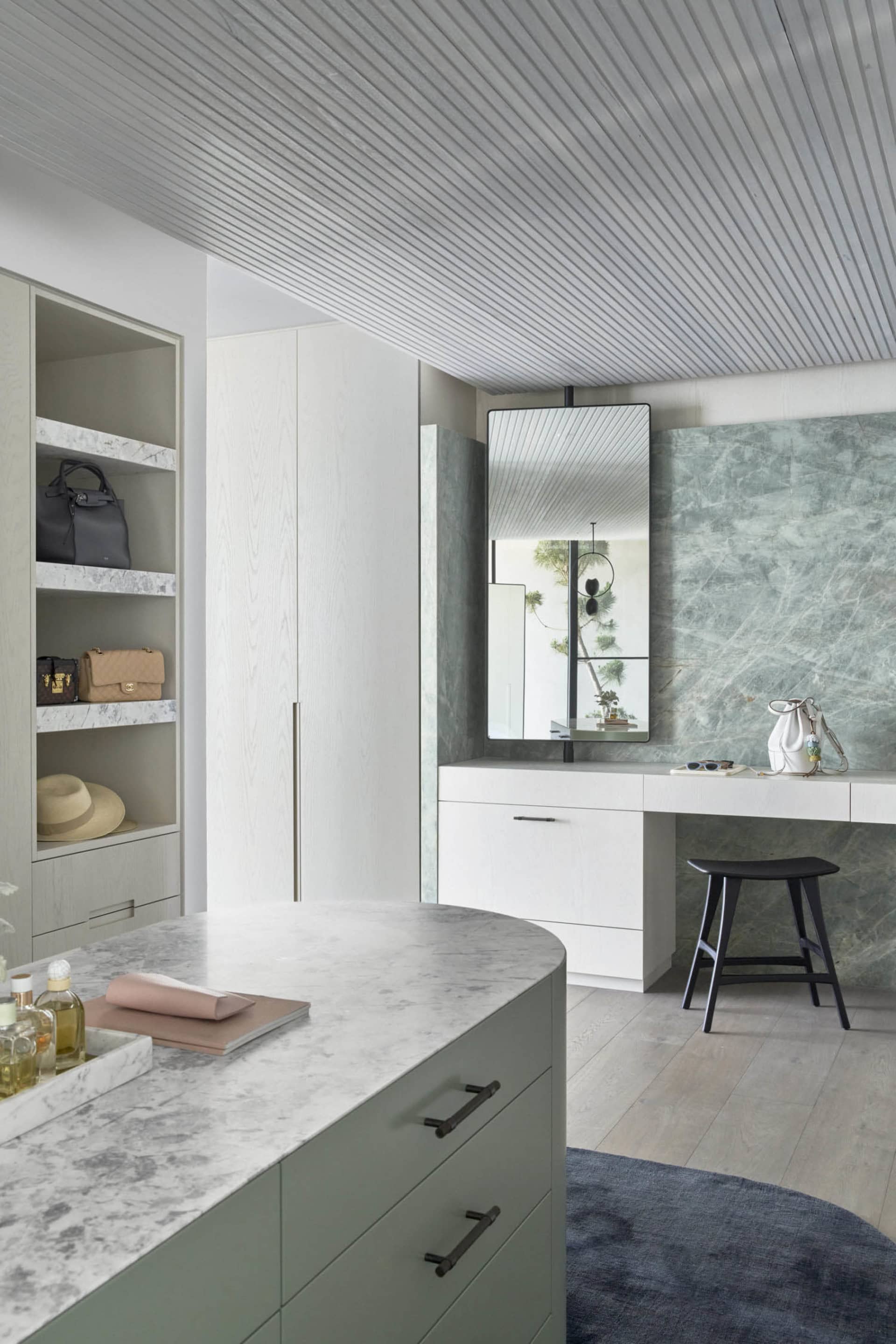 A modern utility room featuring marble countertops and a white wooden cabinet.