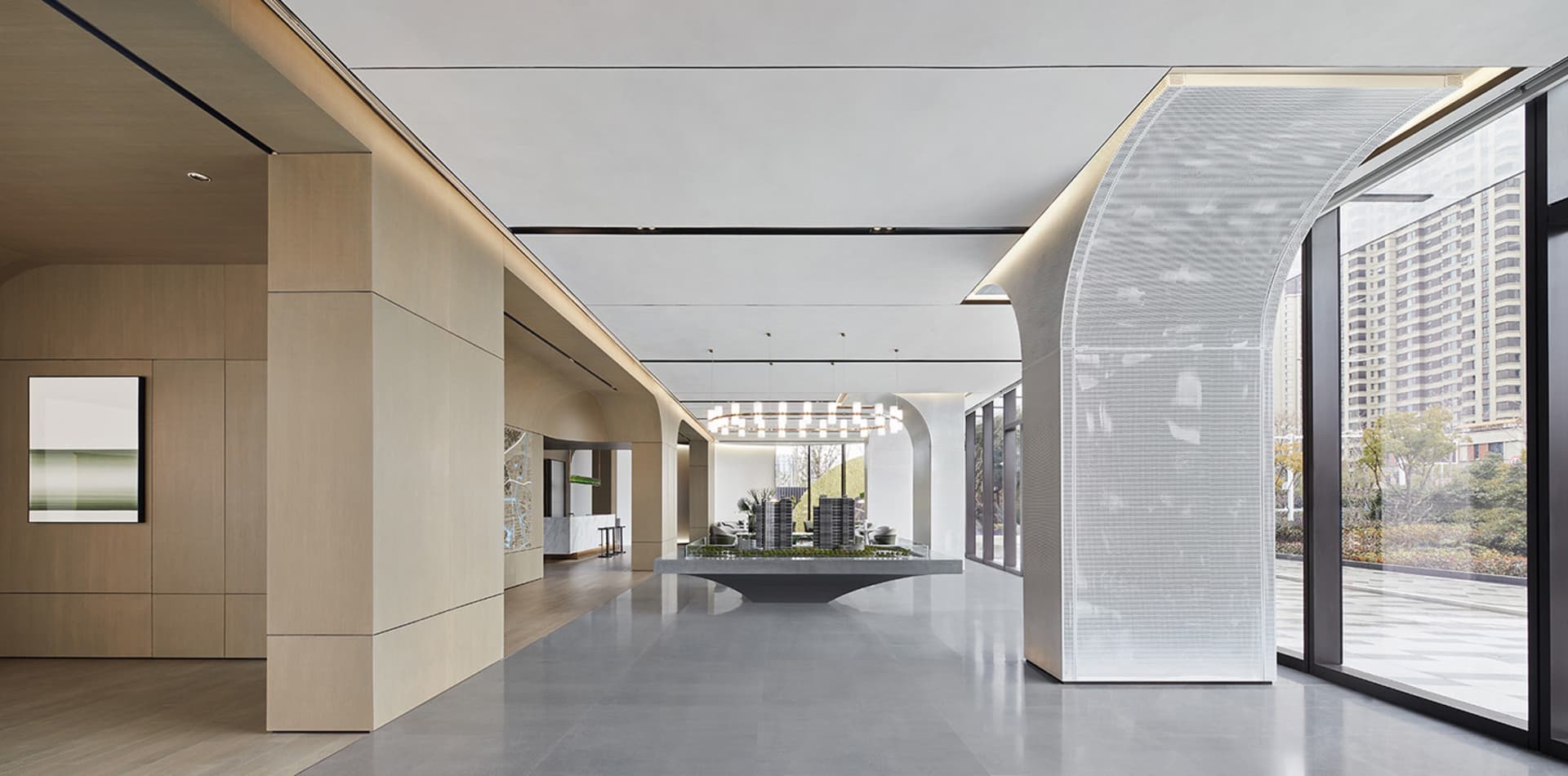 Modern lobby with glass walls and concrete floor.