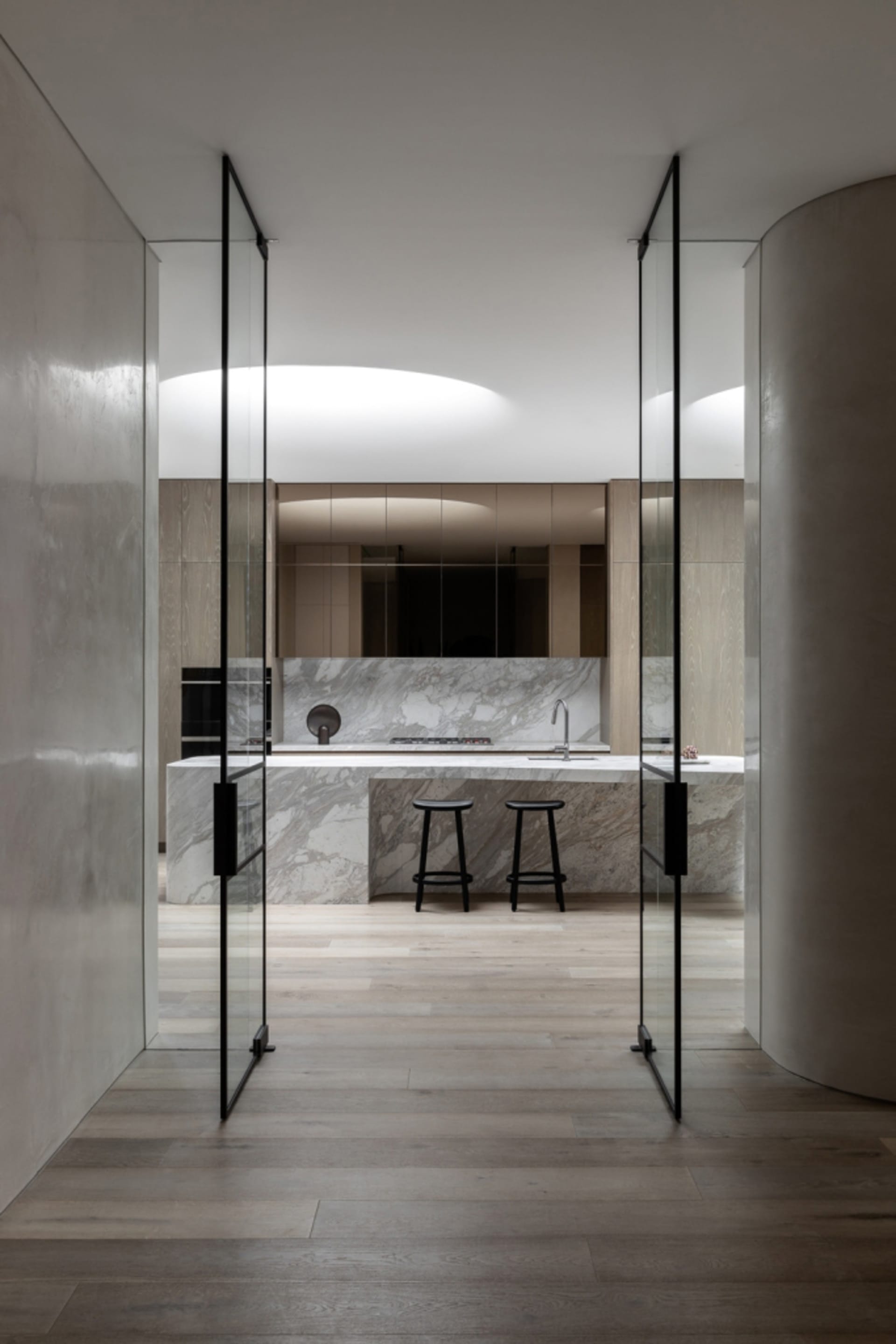 Modern kitchen with marble countertops and wooden flooring.
