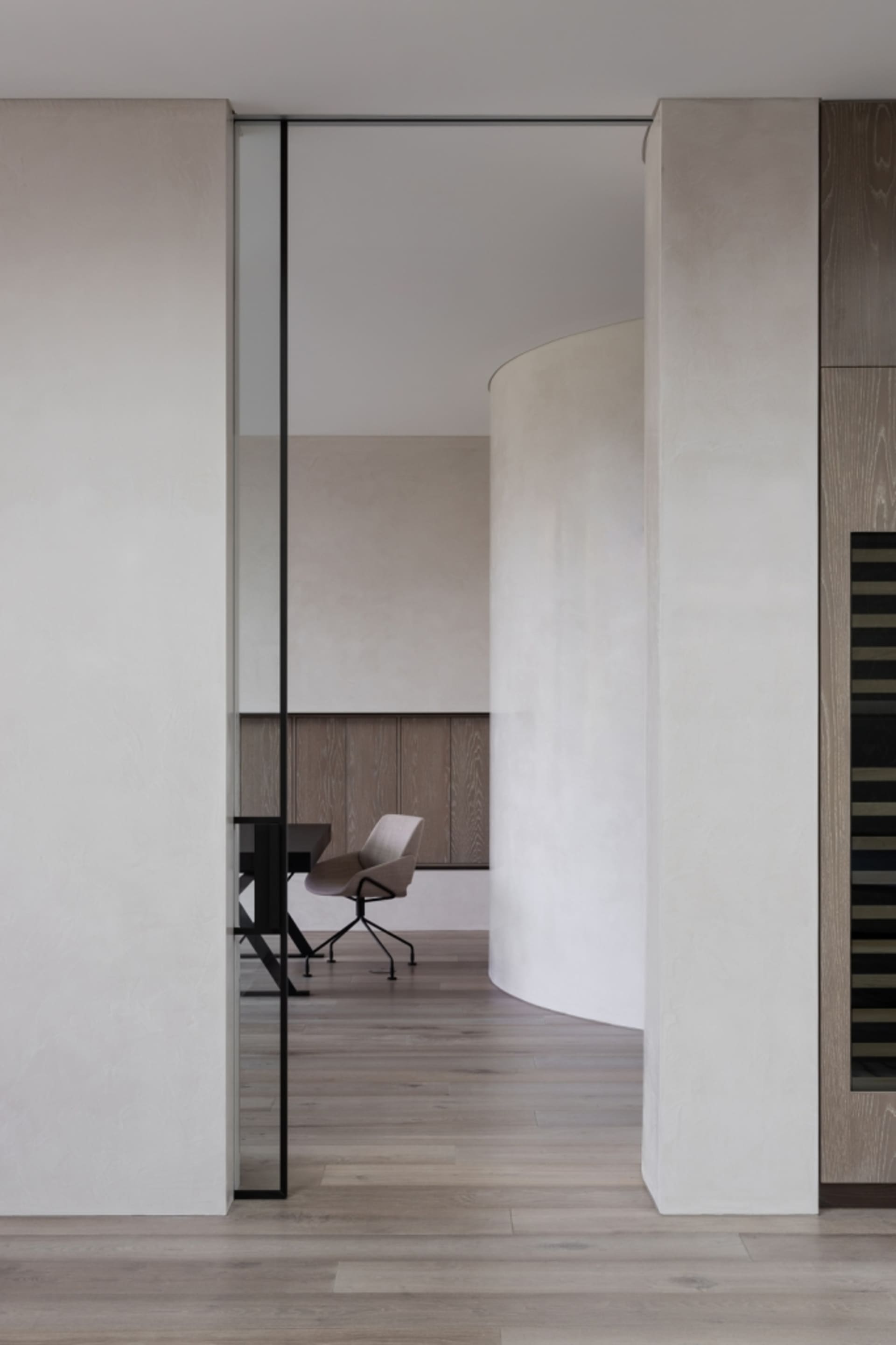 A modern office space featuring white walls and wooden flooring.