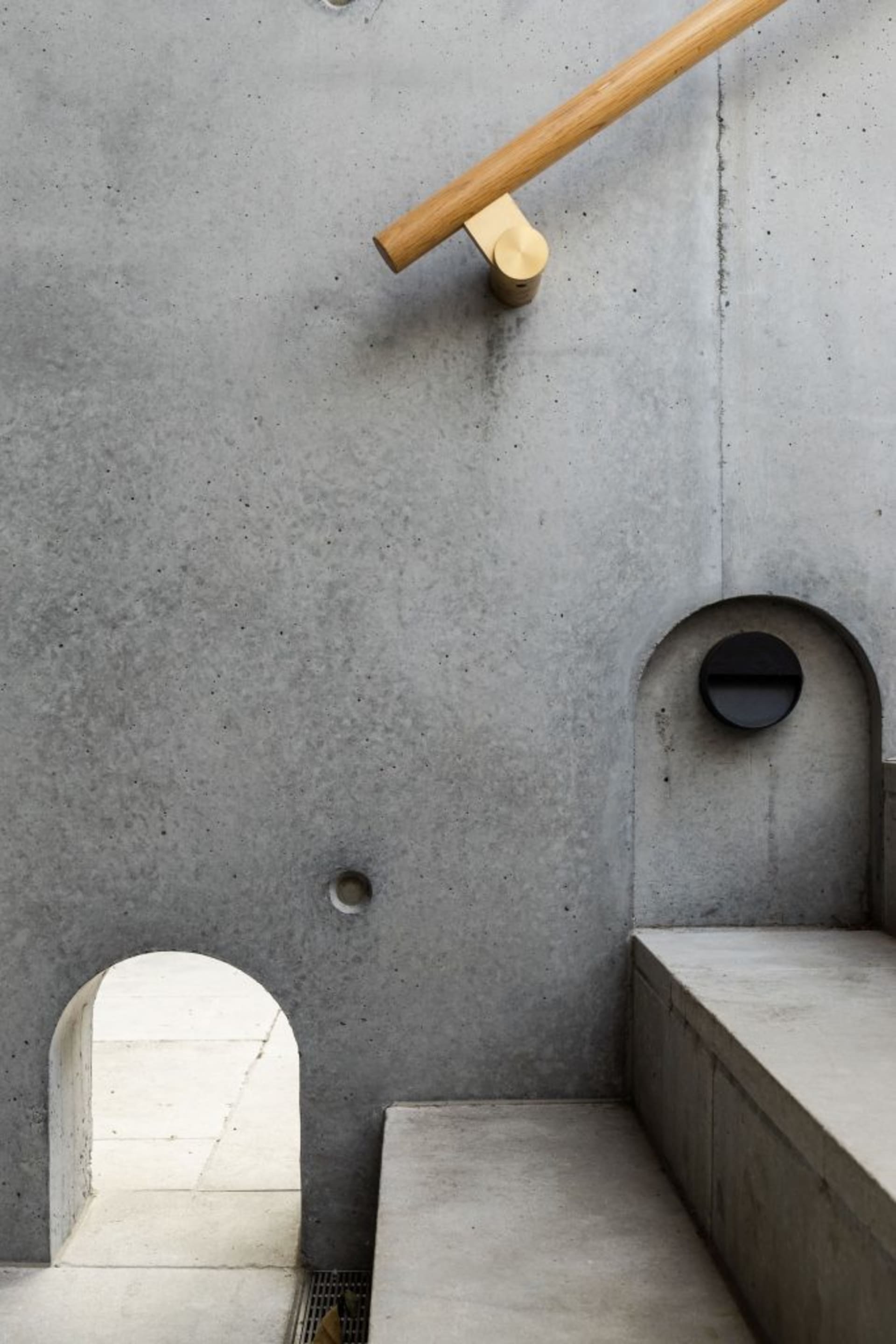 A minimalist radio room with a concrete wall and a circular window.