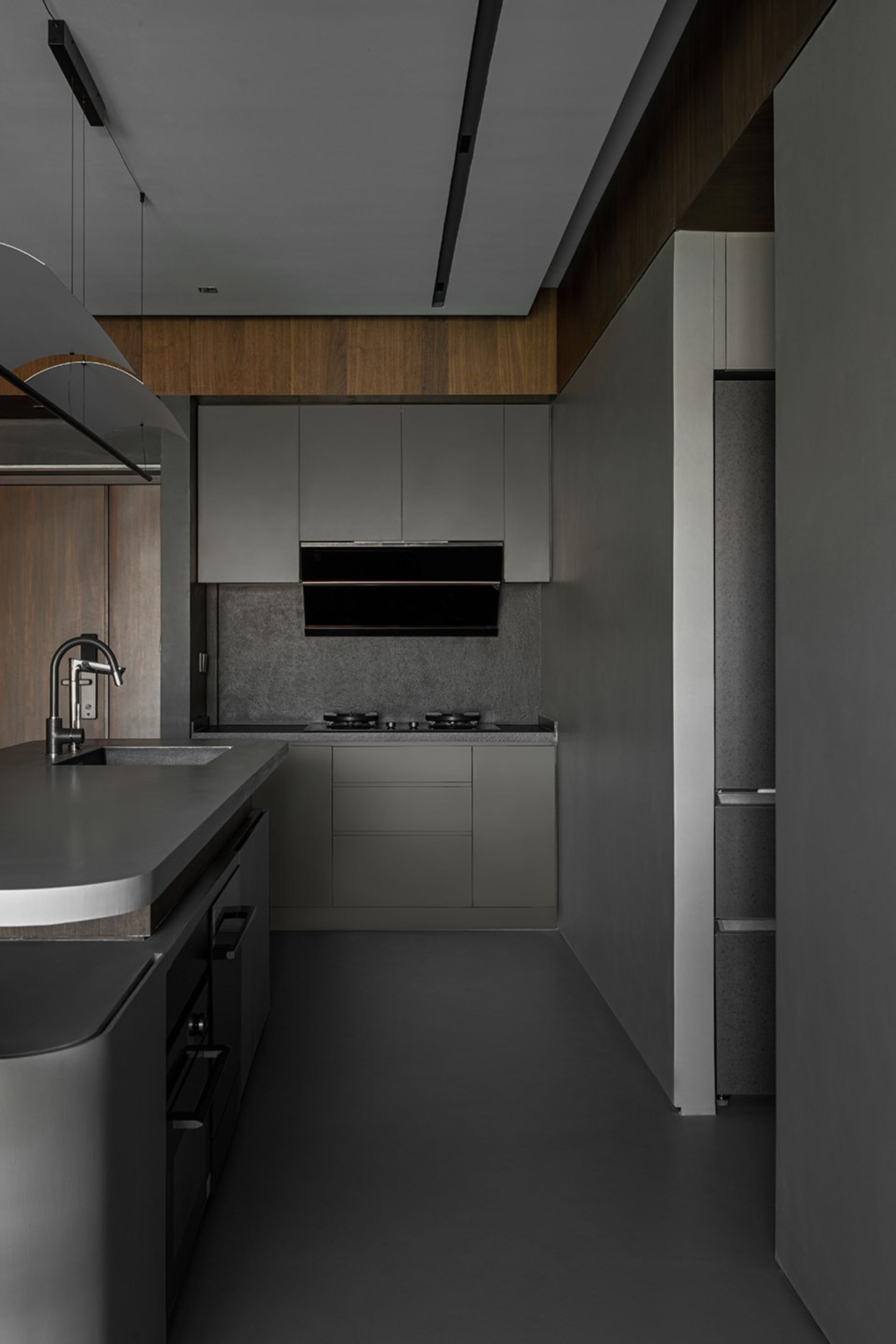 A modern industrial kitchen with concrete countertops and stainless steel appliances, featuring sleek, minimalist design.