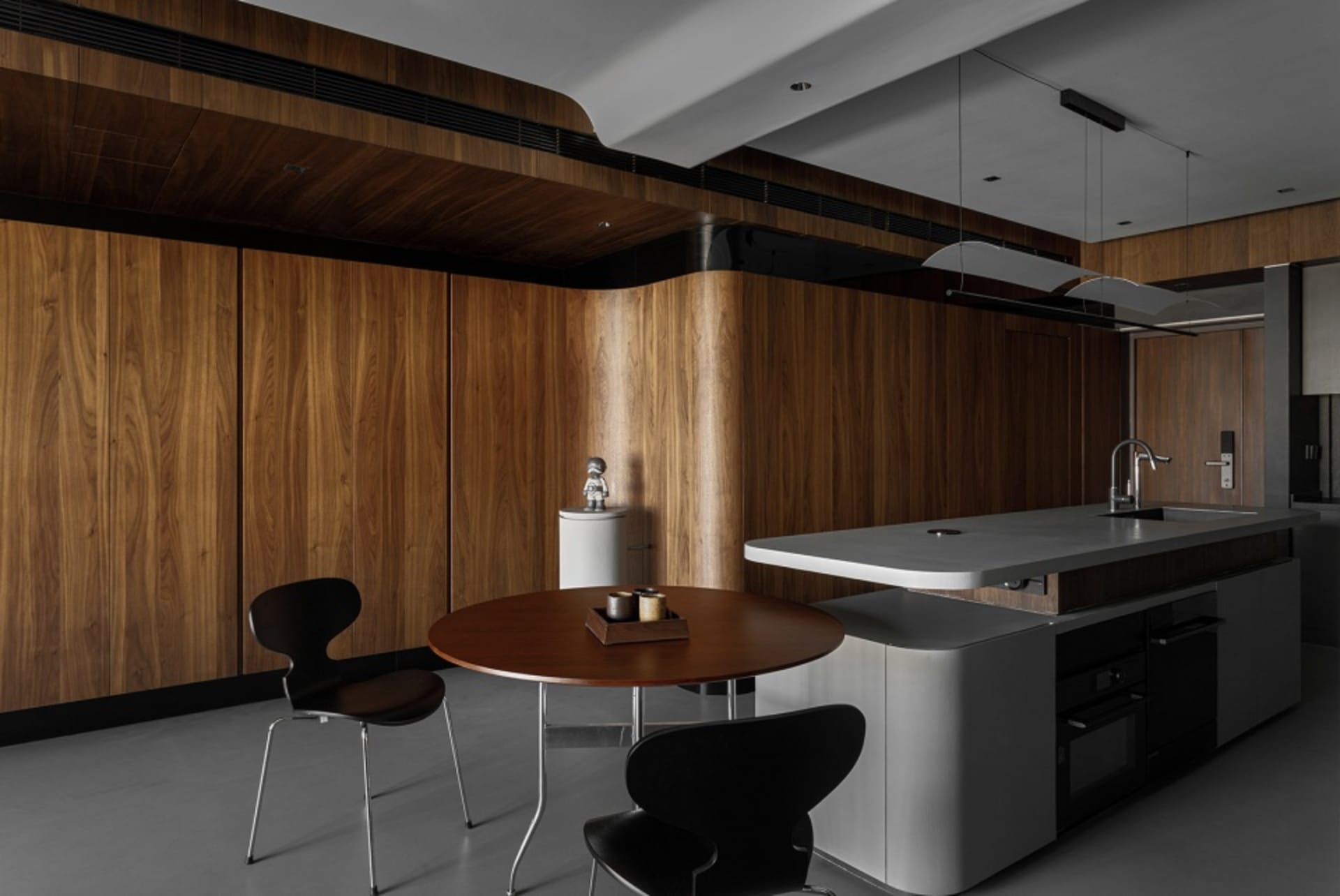 A modern residential kitchen featuring wooden cabinets and a concrete countertop.