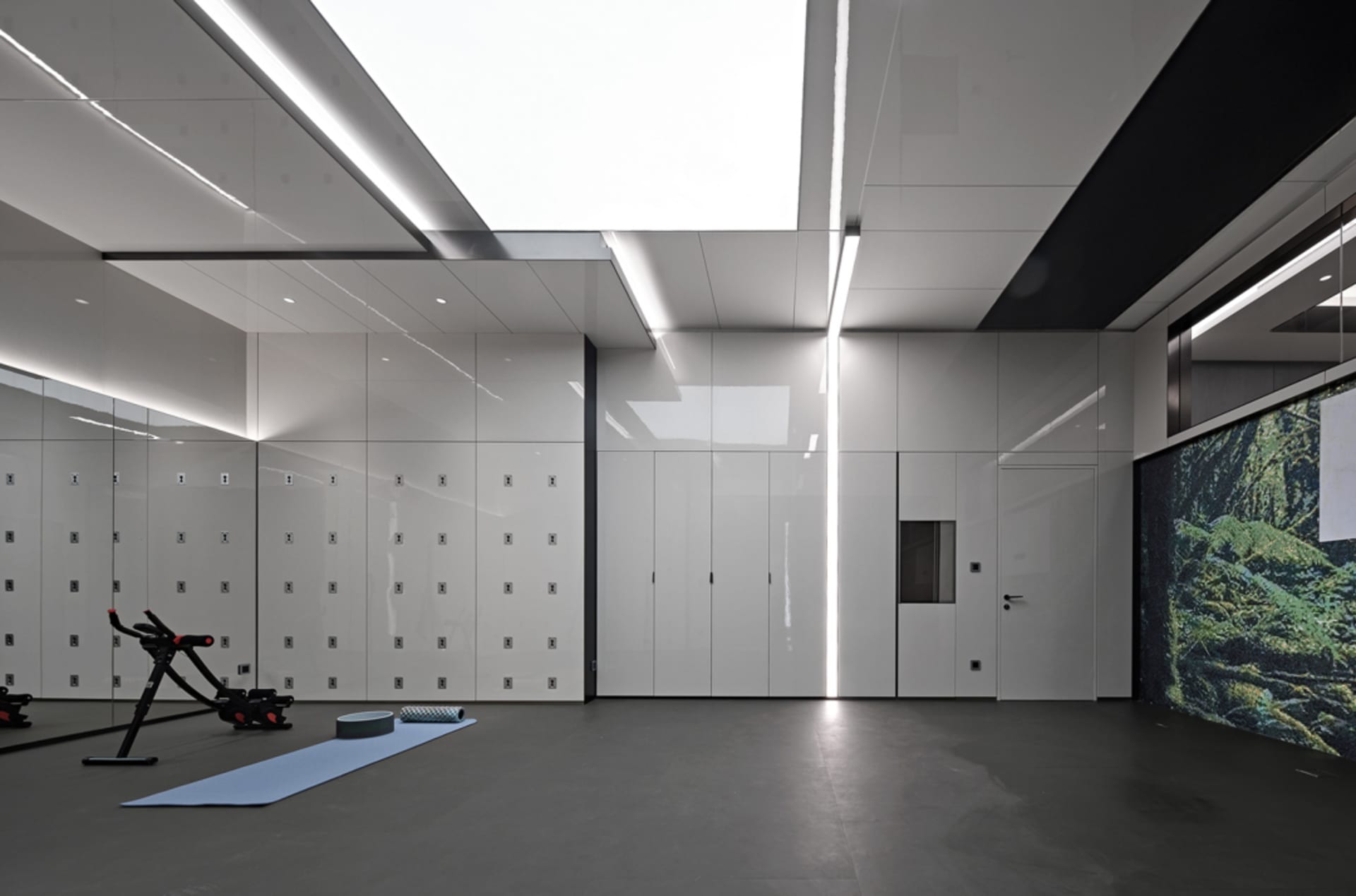 A sleek, minimalist fitness center with concrete flooring and white walls.