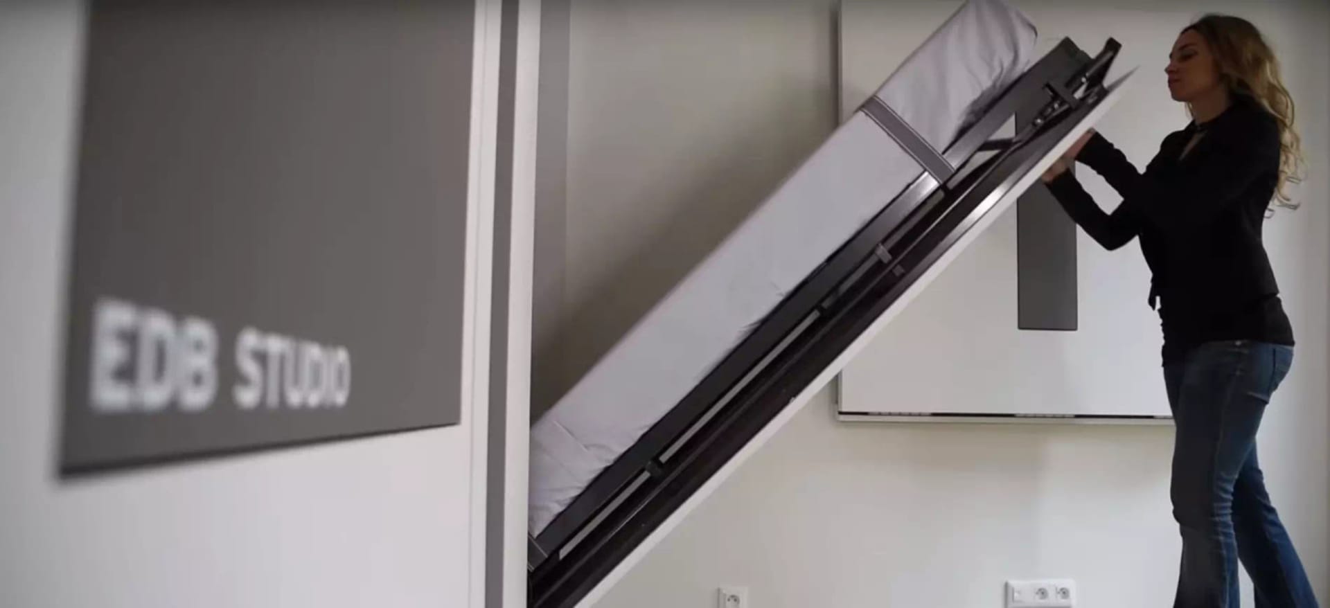 A wall-mounted bed with hidden storage compartments.