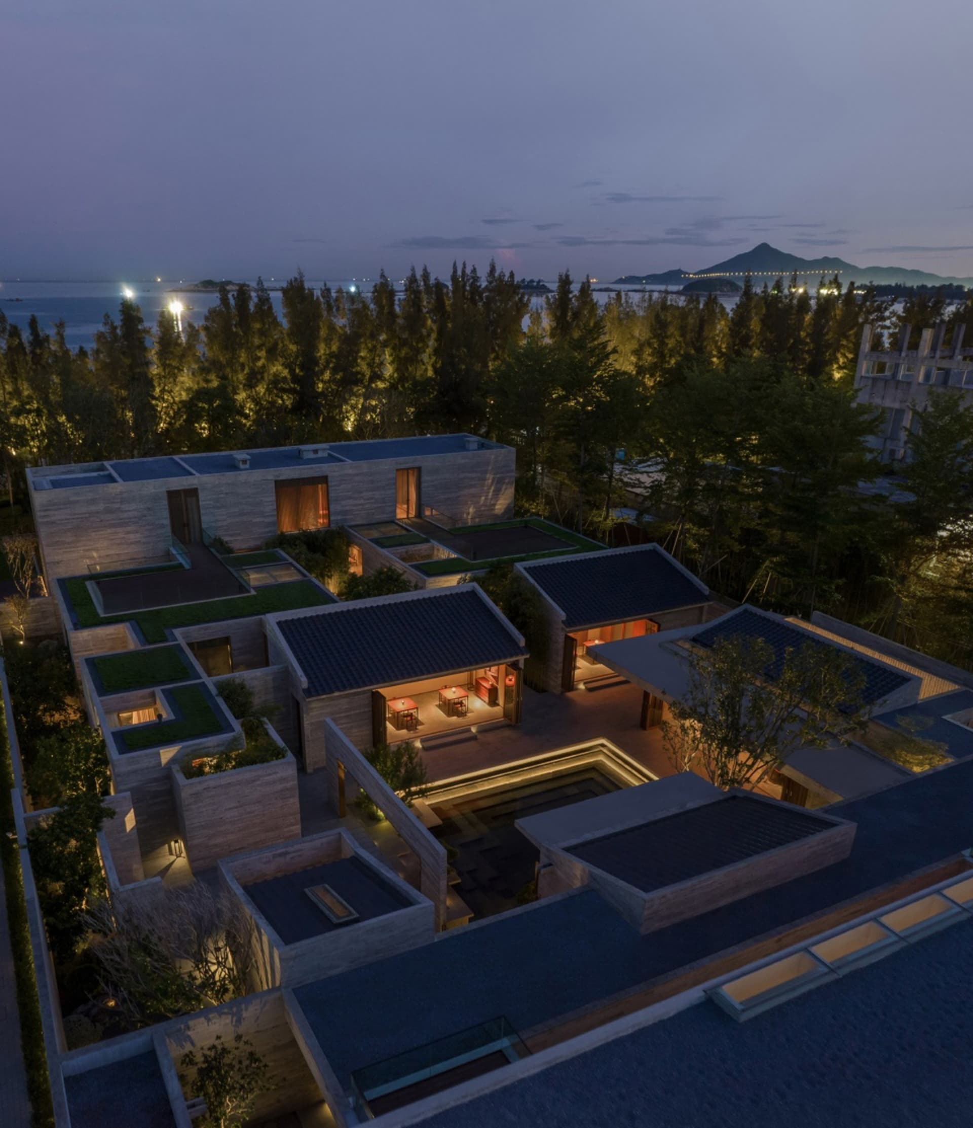Aerial view of a modern residential building featuring wooden structures, glass walls, and concrete elements.