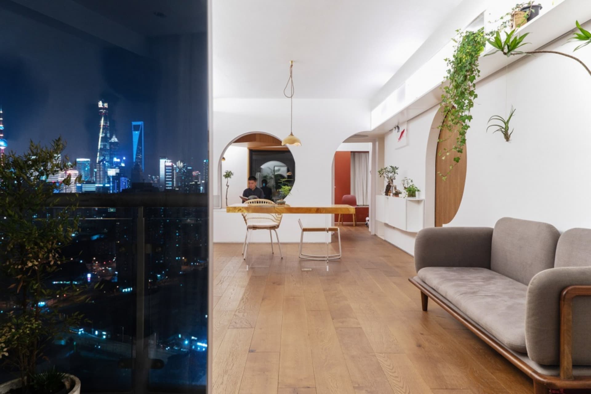 現代客廳夜景,木質地板與玻璃牆面,眺望城市景觀。