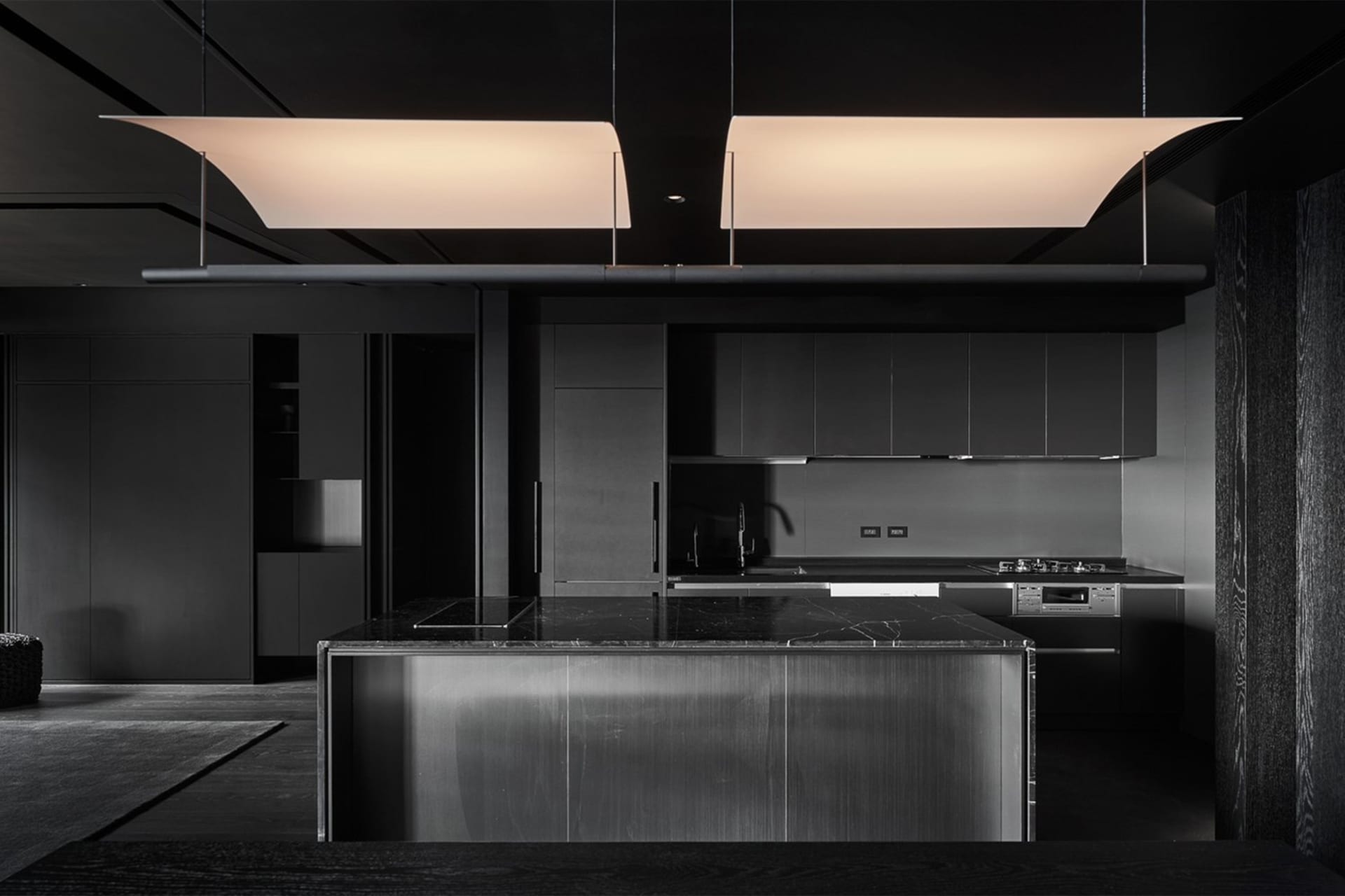 Modern kitchen with a minimalist design featuring marble countertops and stainless steel appliances.