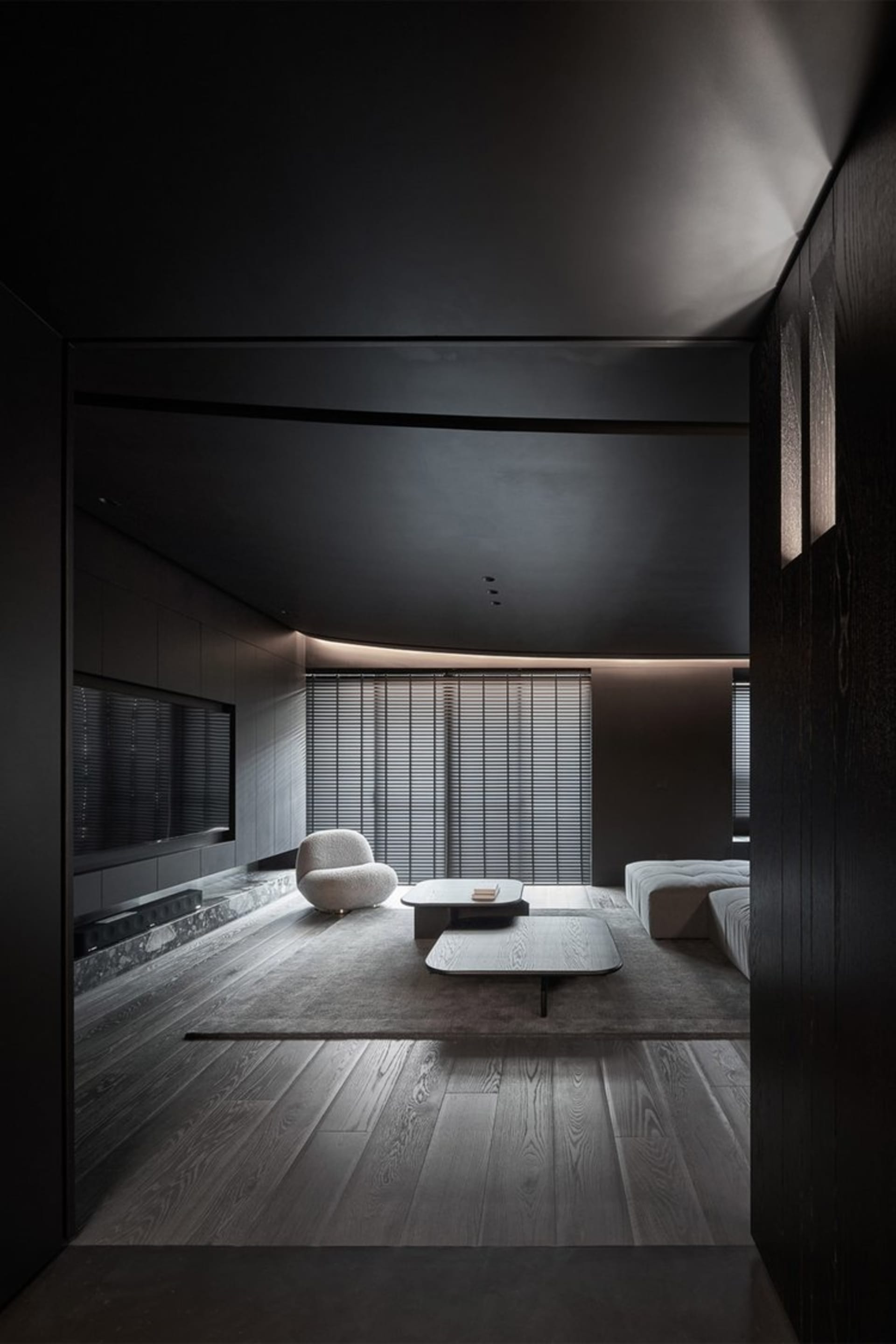 A modern living room with dark wood furniture and a minimalist design.