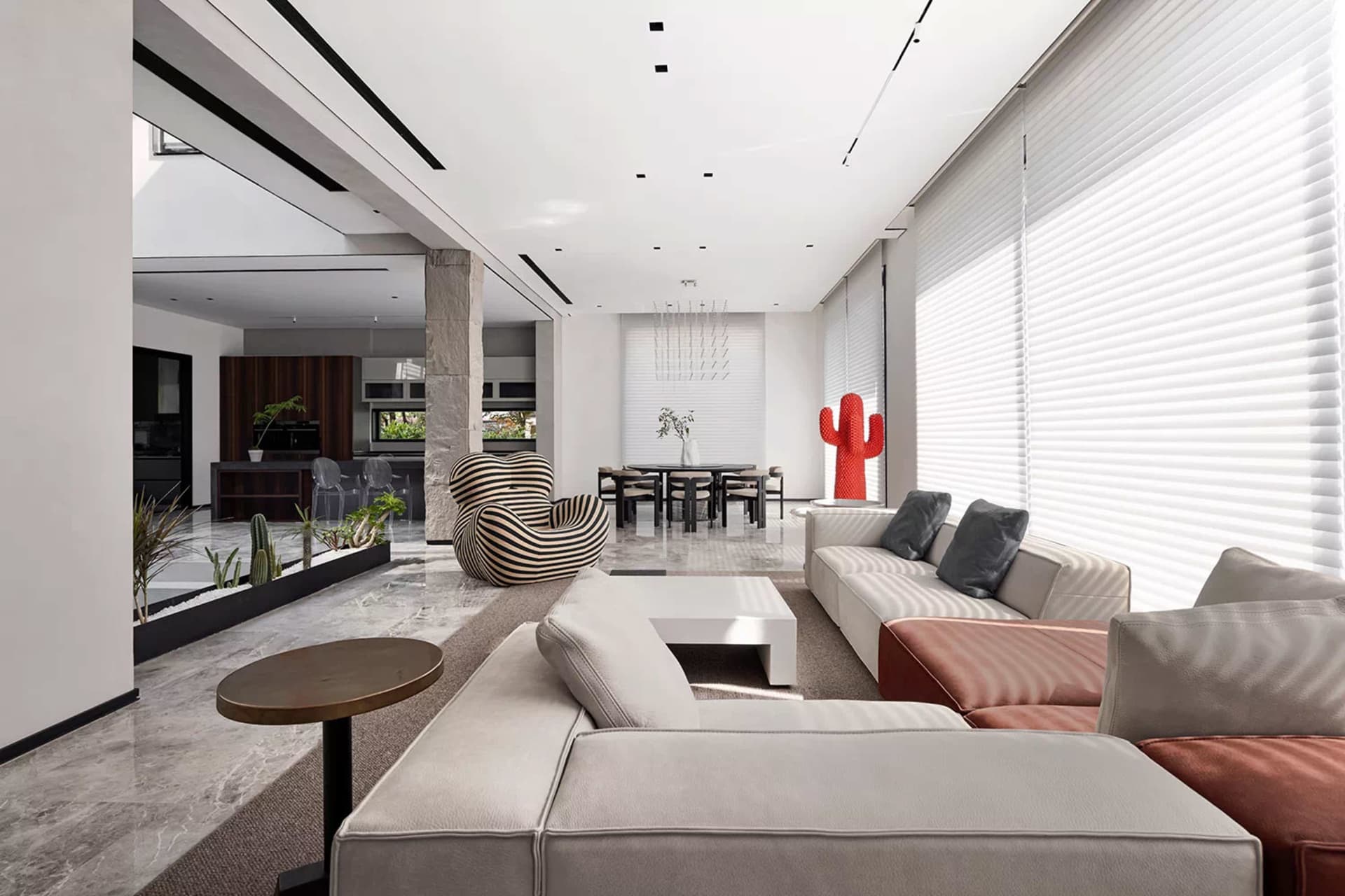 A modern living room with concrete and marble floors, large windows, and contemporary furniture, including a large white sofa