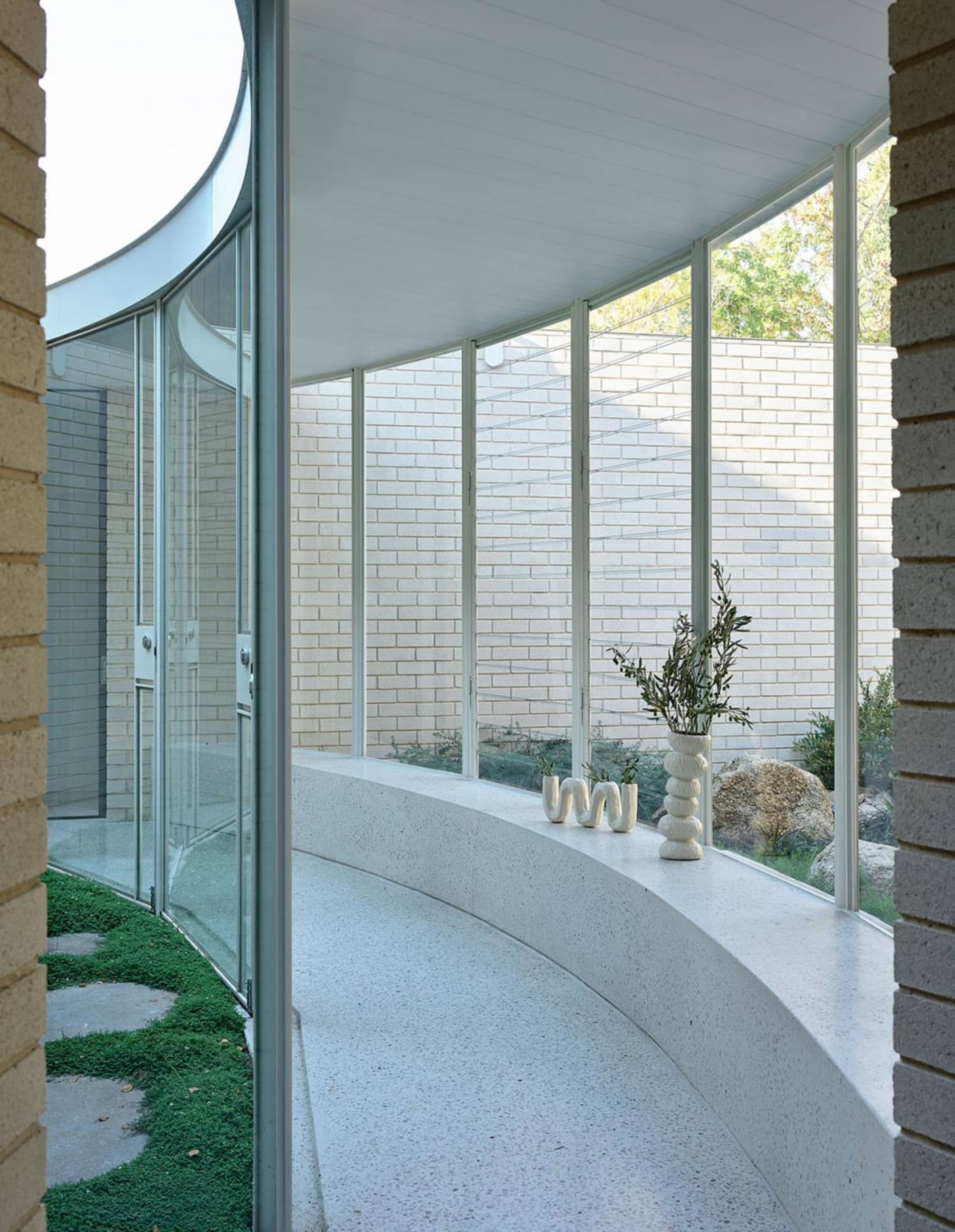 A modern interior featuring white brick walls and concrete flooring.