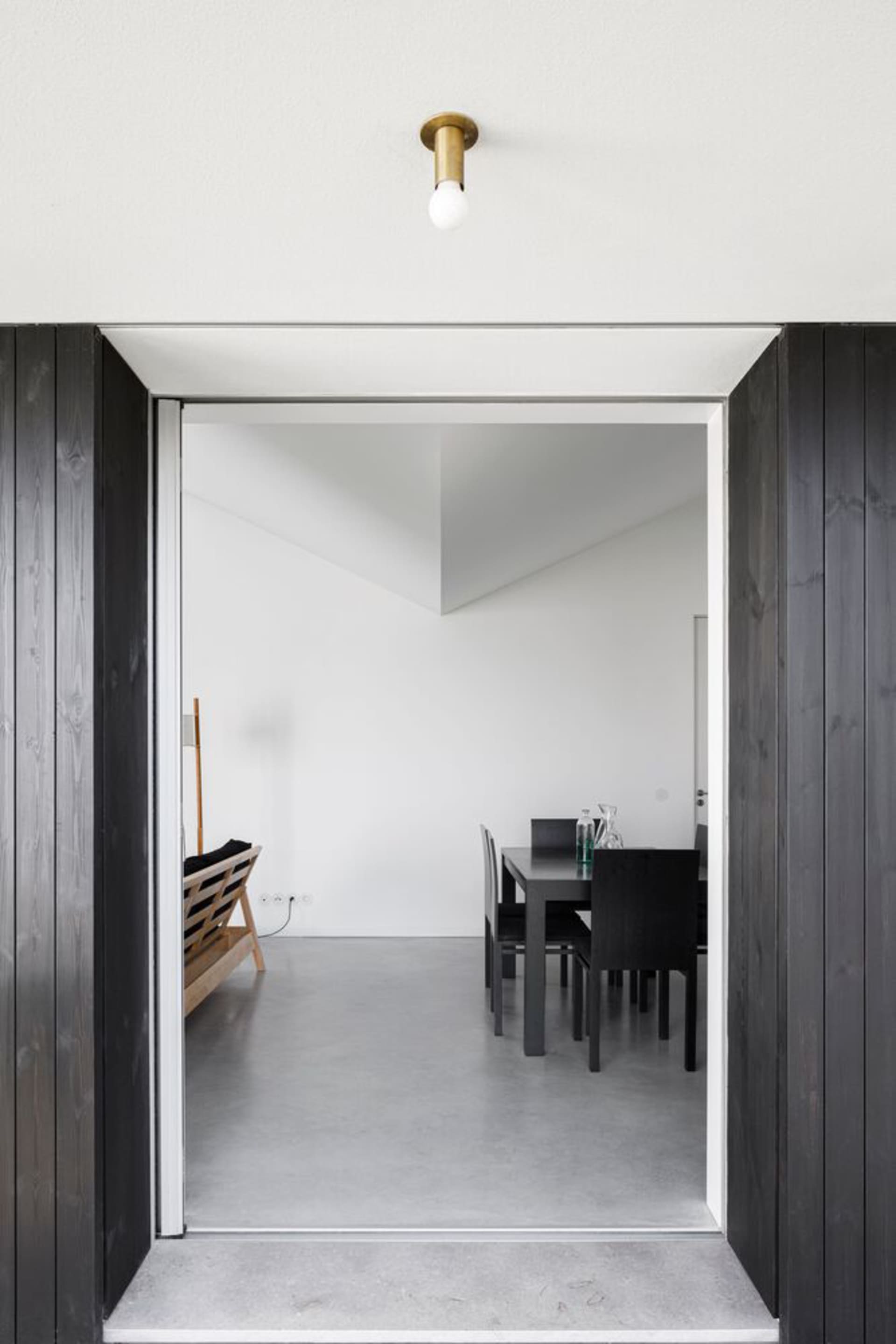 Modern, interior design featuring a room with concrete flooring and minimalist furniture.