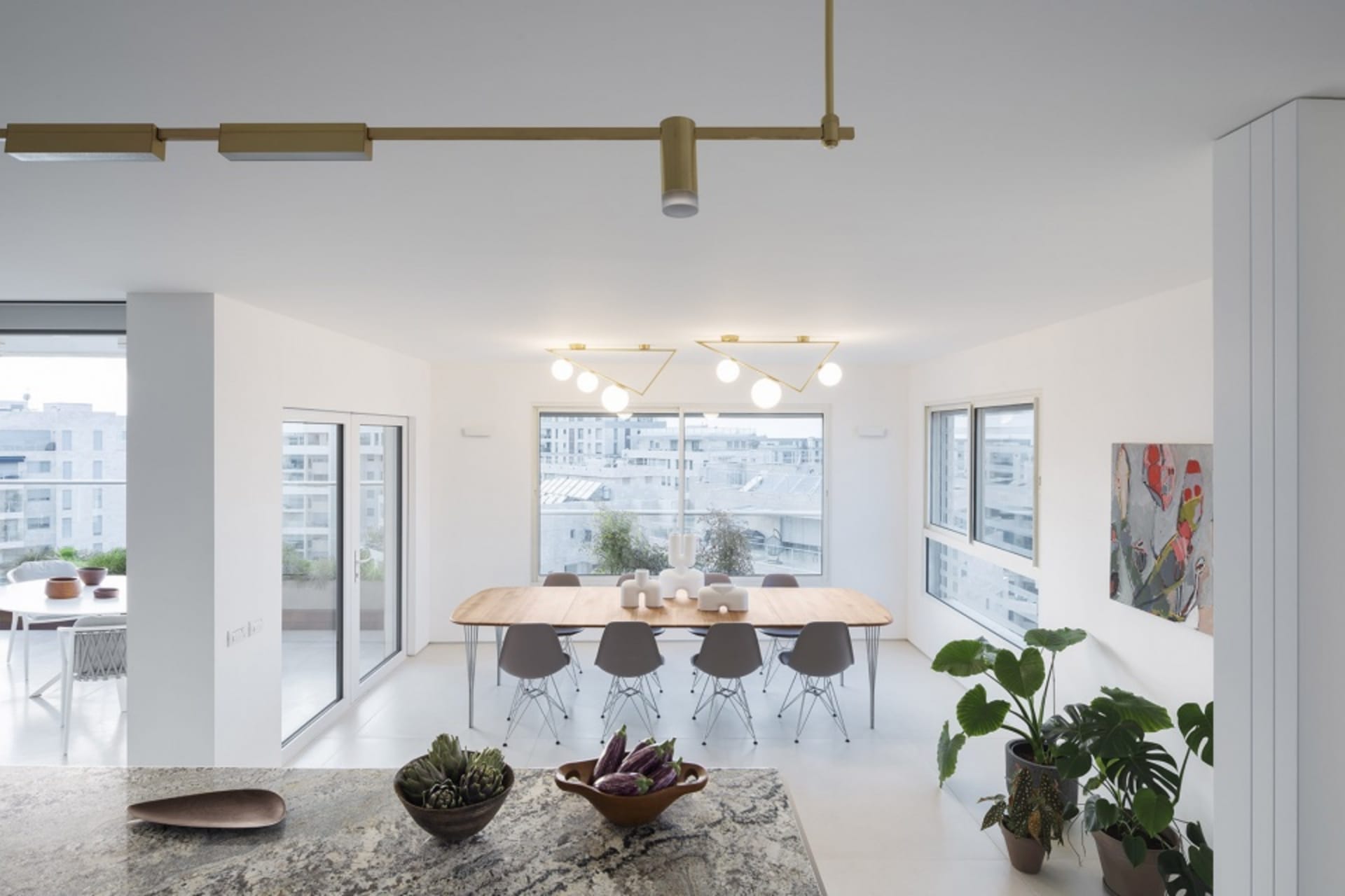 Contemporary dining room featuring wooden furniture, glass windows, and potted plants.