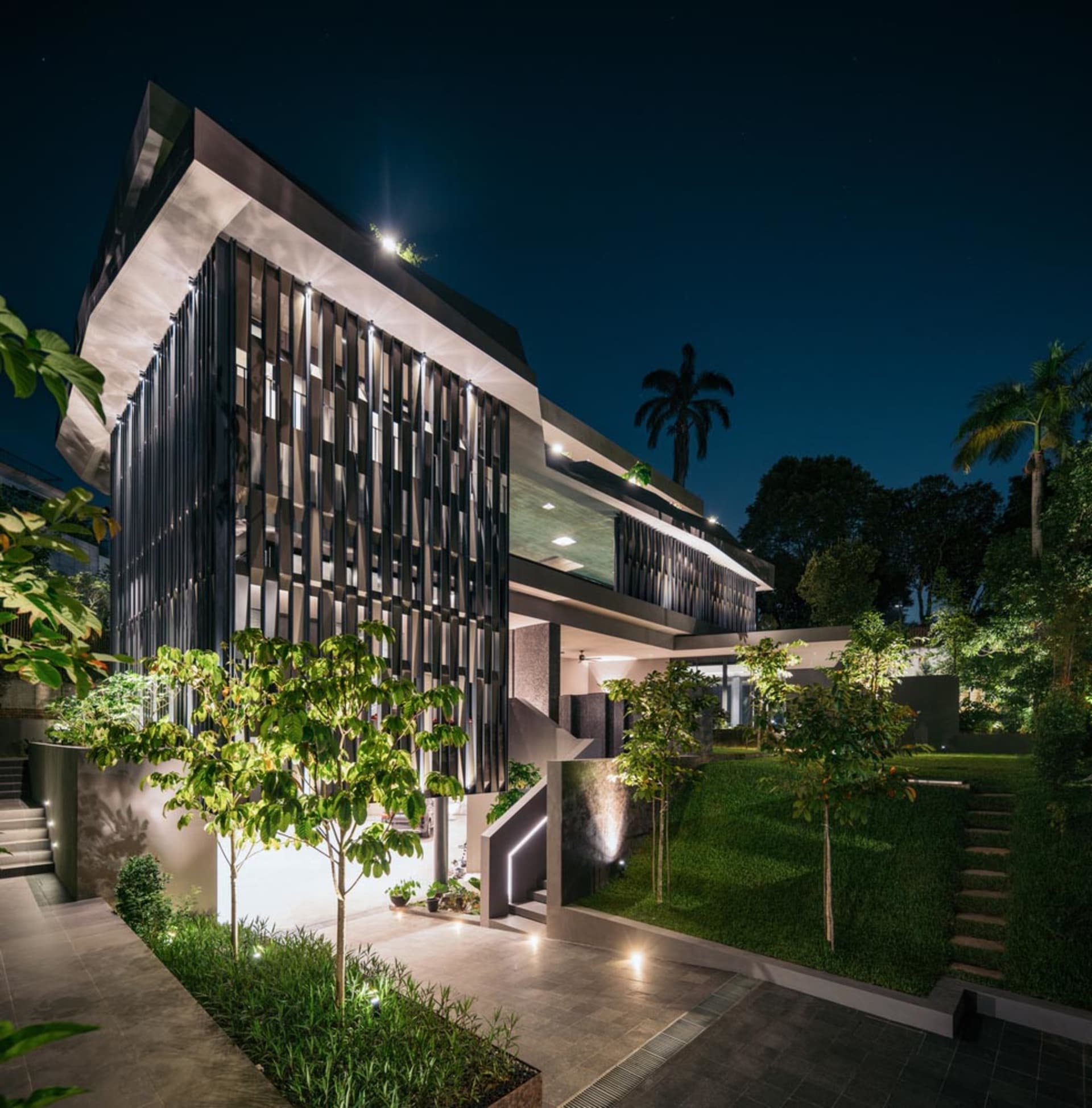 夜晚的現代住宅建築，外牆採用玻璃與金屬材質。