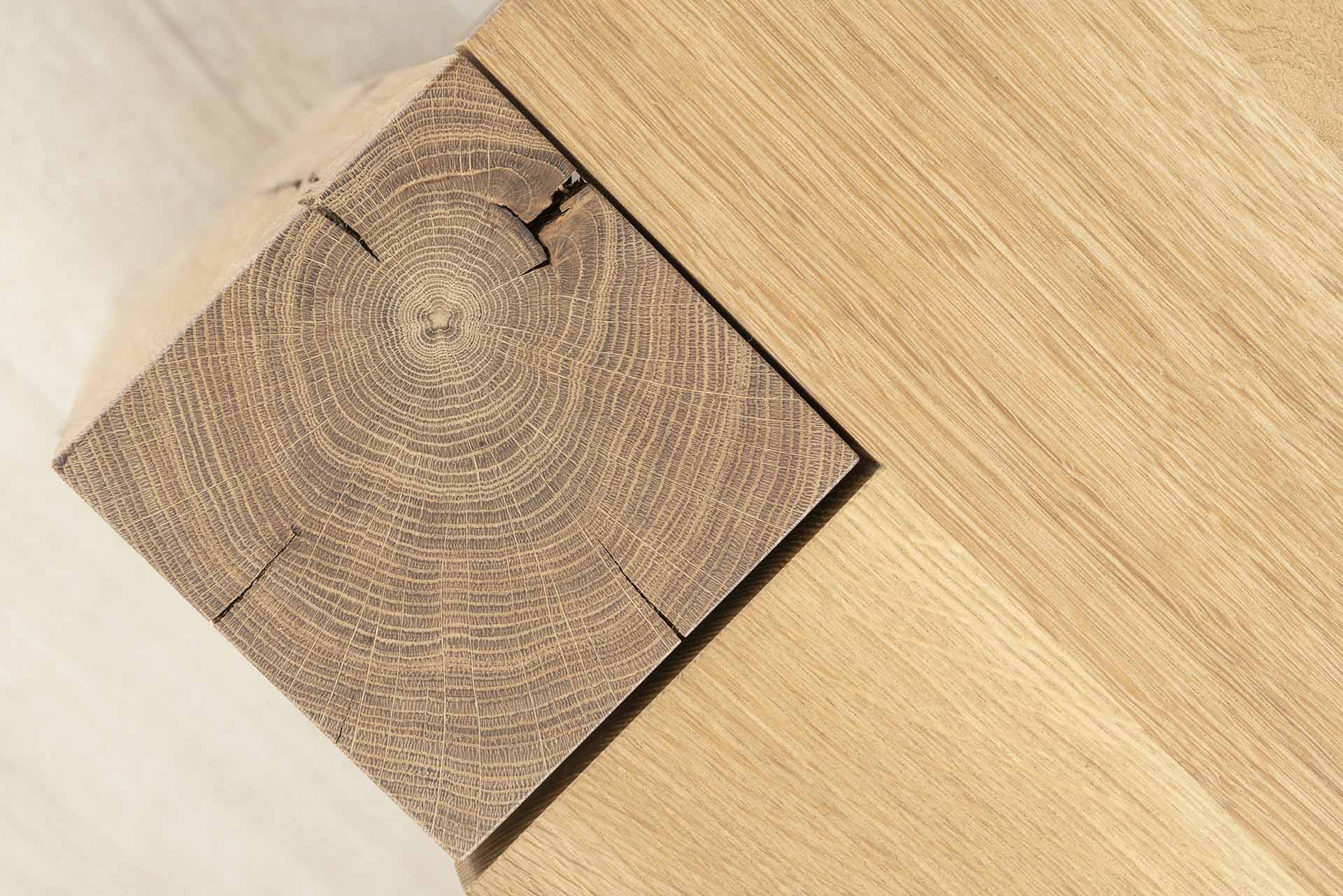 A close-up view of a modern interior design featuring a wooden floor with visible annual rings and a clean, minimalist aesthe