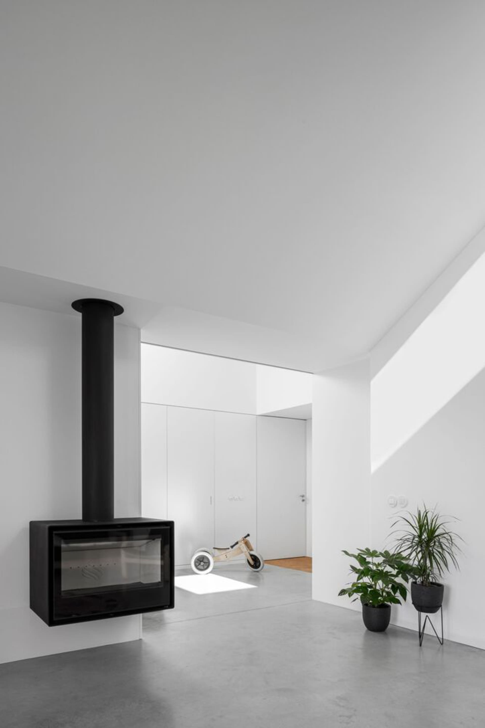 A minimalist interior design featuring concrete elements and a hanging fireplace.