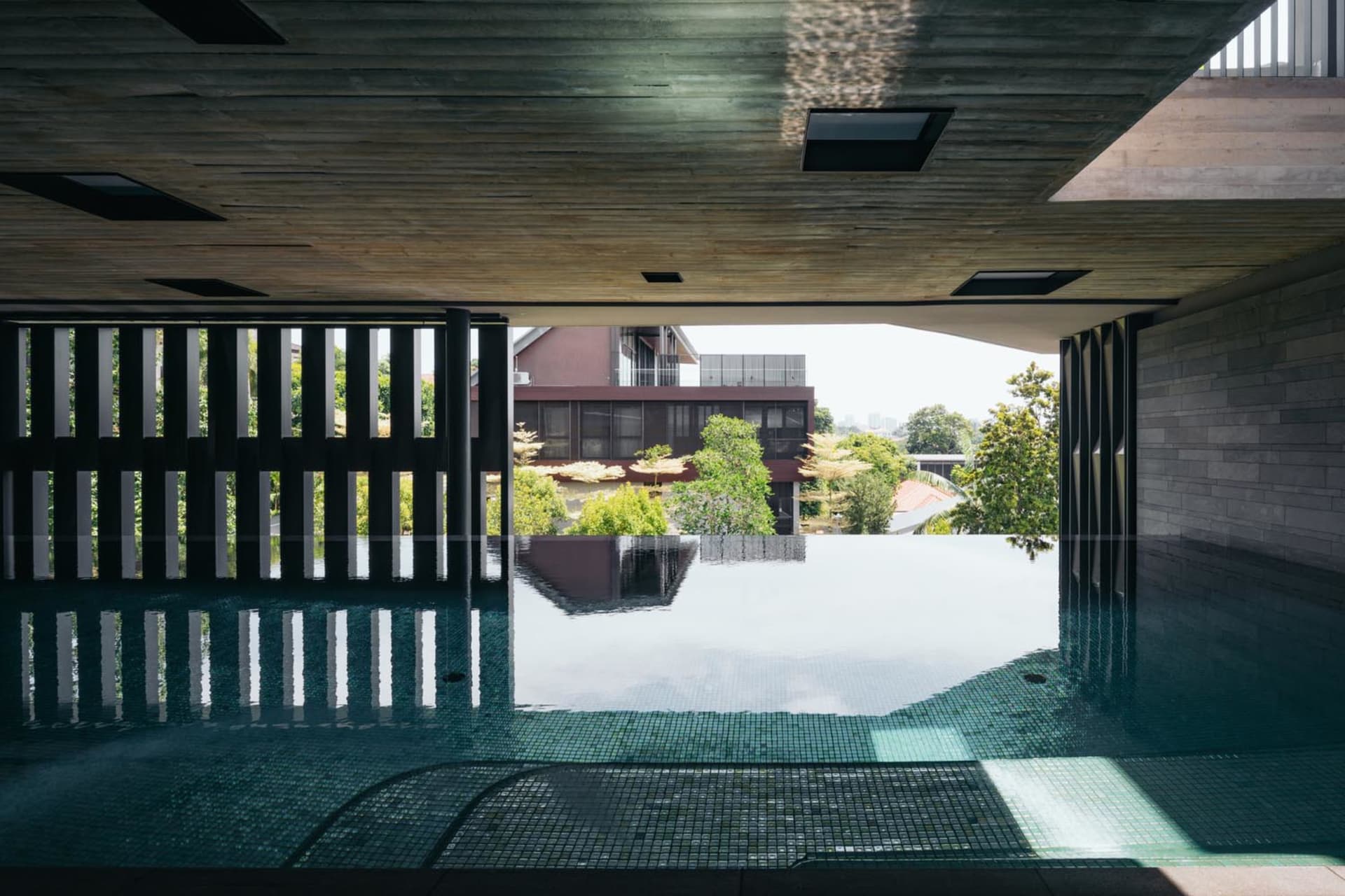 Indoor infinity pool with glass-tile and concrete elements.