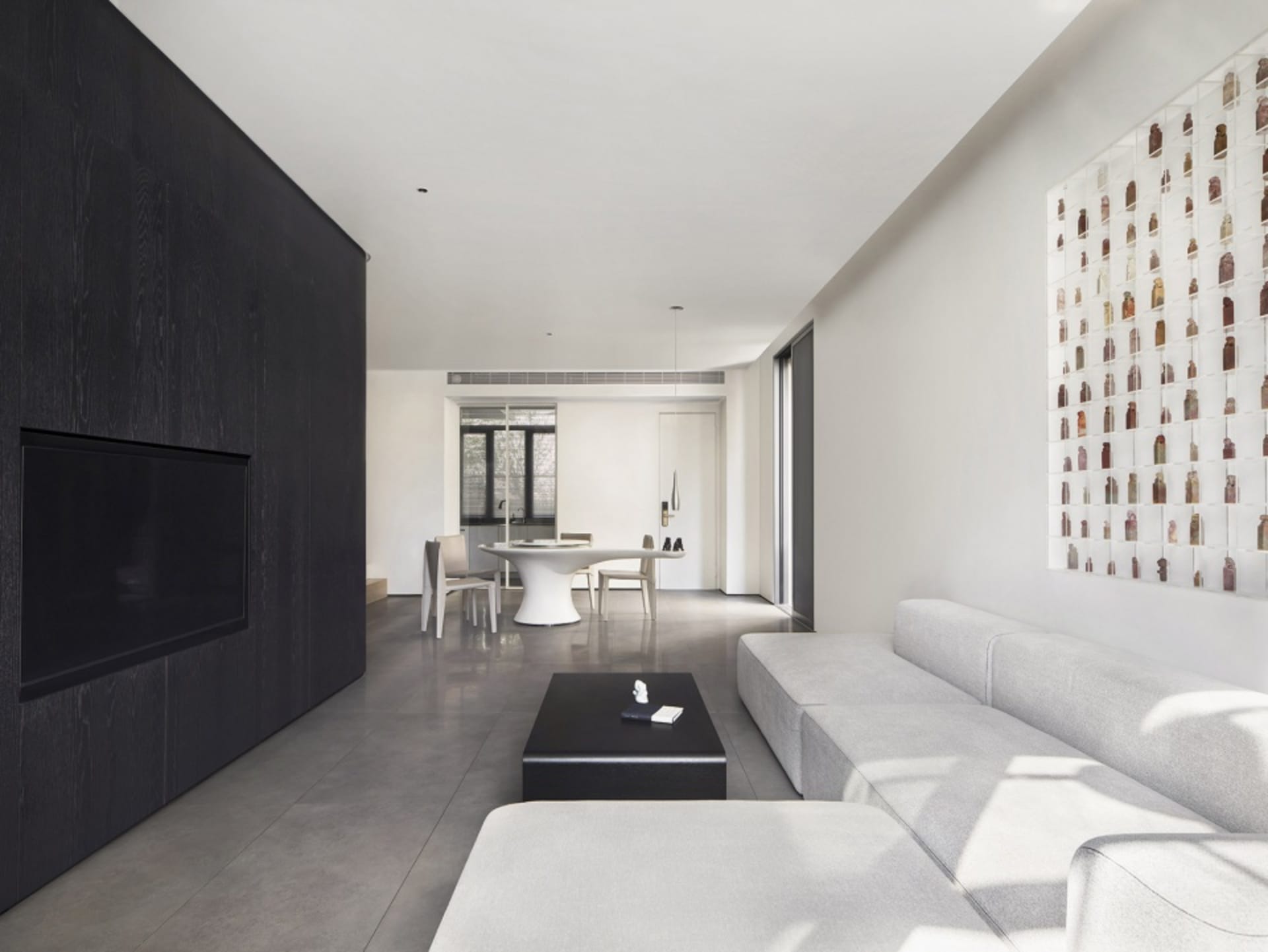 A minimalist living room with a concrete floor and leather sofa.