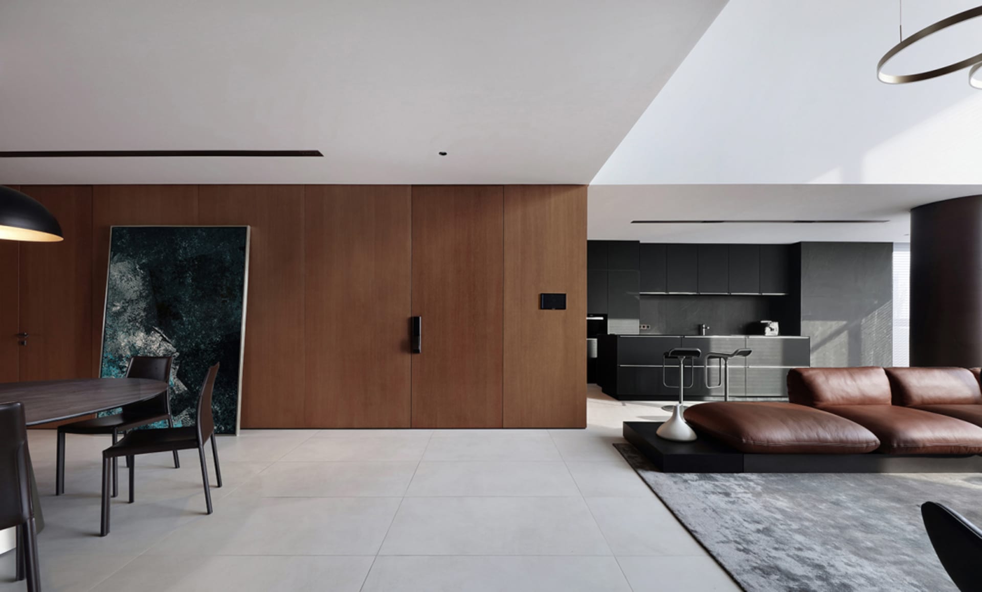A modern minimalist living room featuring wooden walls, a leather couch, and metal accents.