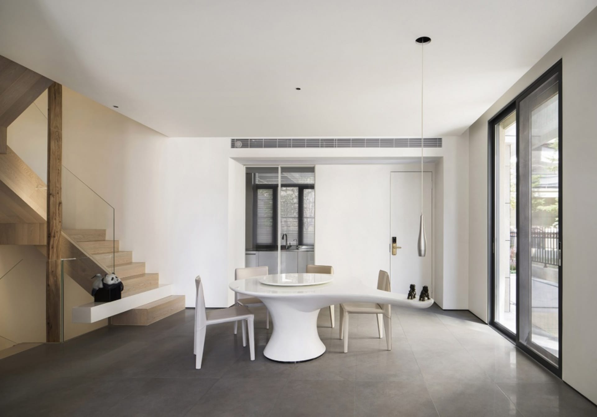 A modern dining room features a white table and chairs, with a sleek, minimalist design.