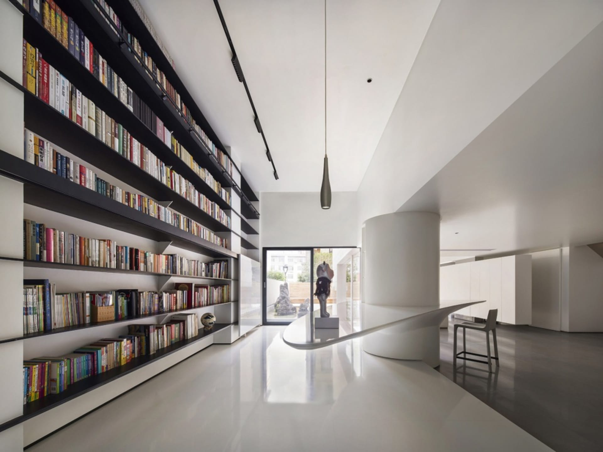A modern interior design featuring a library with sandblasted concrete shelving.
