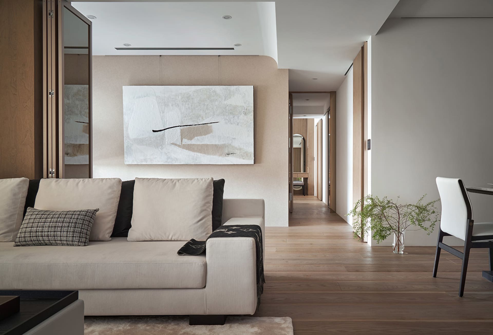Modern living room with neutral-colored furniture and abstract artwork on the wall.