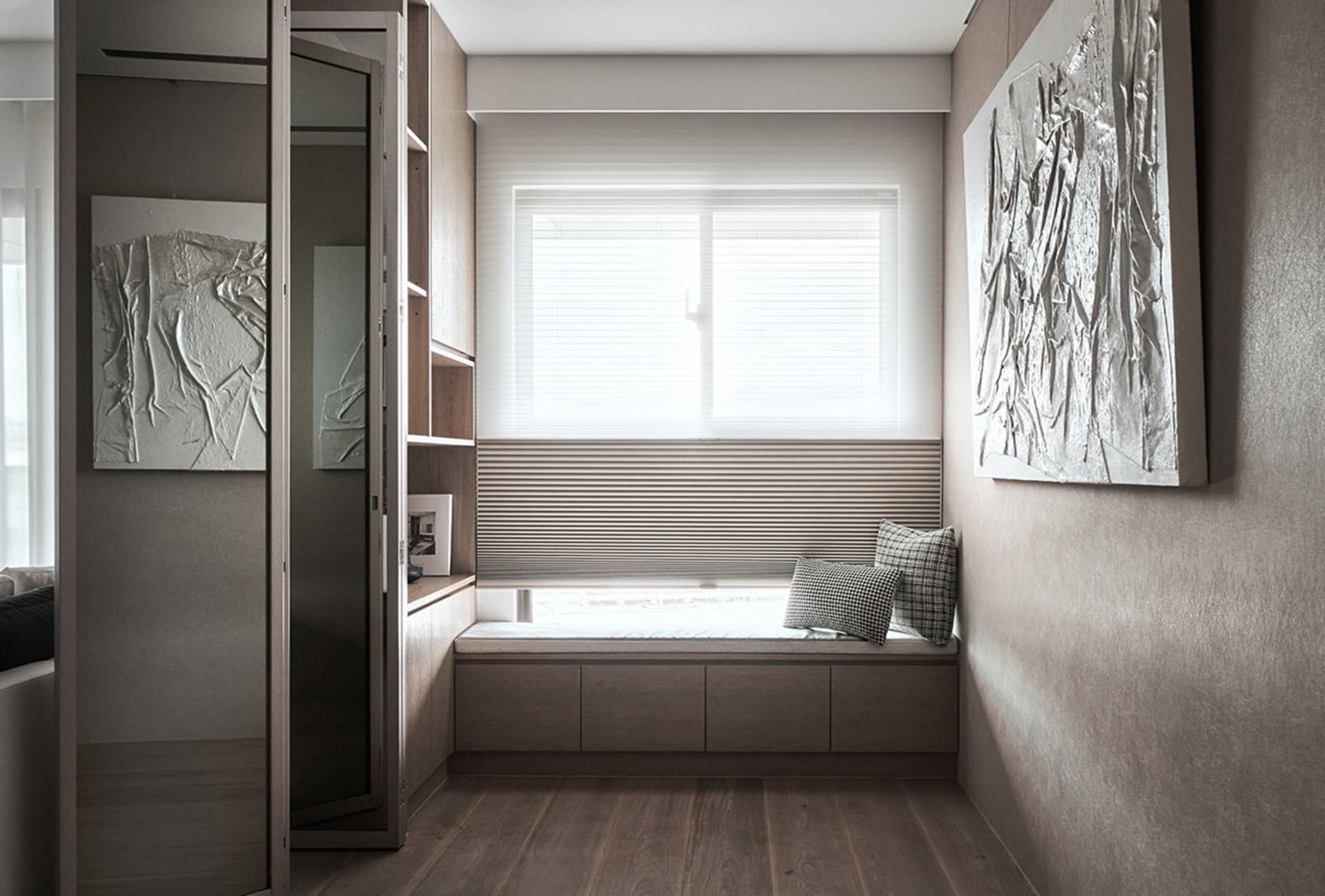 Modern bedroom featuring wooden furniture and a comfortable seating area by the window with blinds.