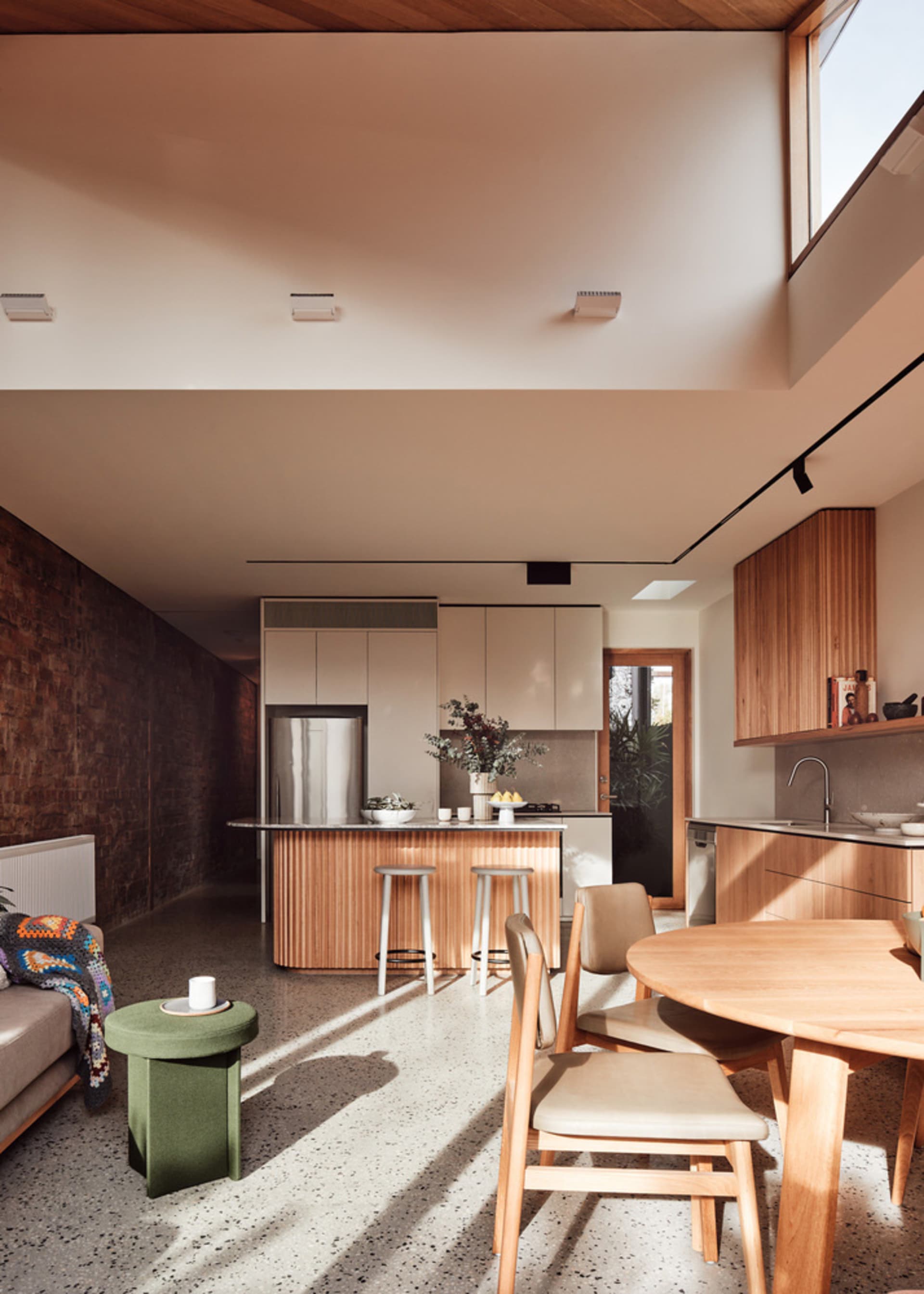 A modern residential kitchen featuring minimalist design and wooden surfaces.