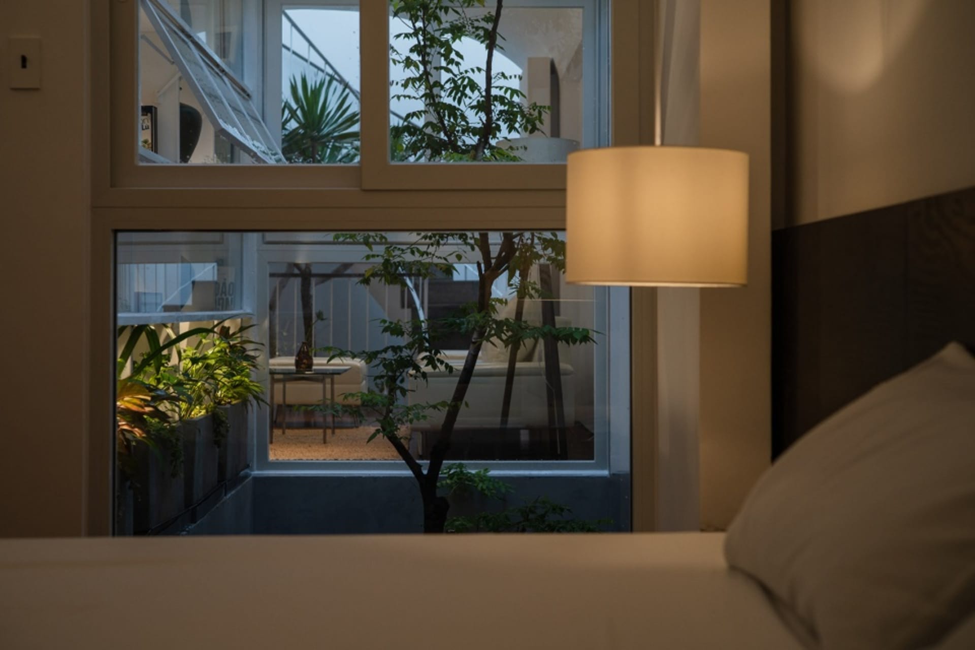 A contemporary bedroom with textured wallpaper and plants.