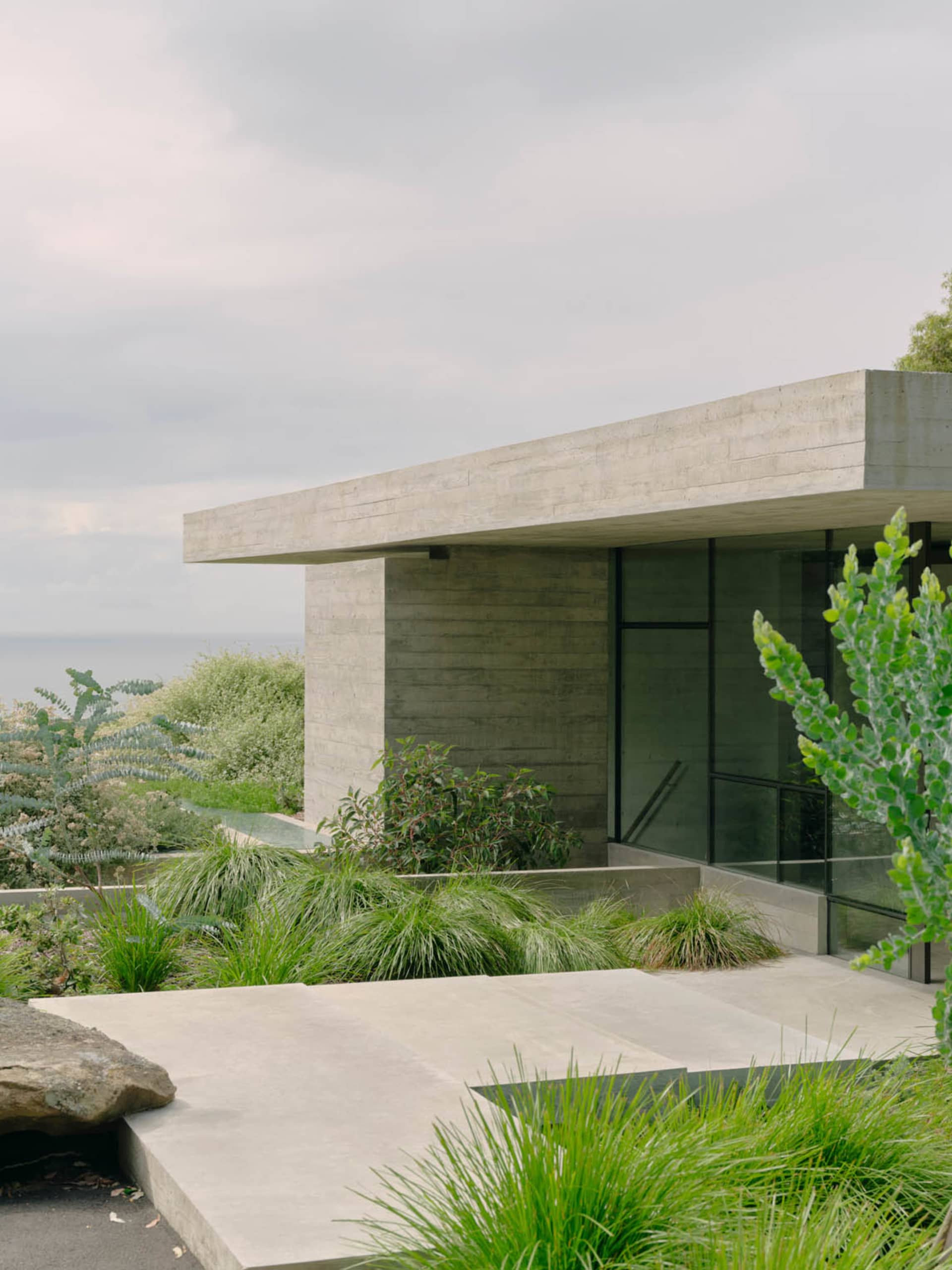 A minimalist design features a concrete structure with glass windows.