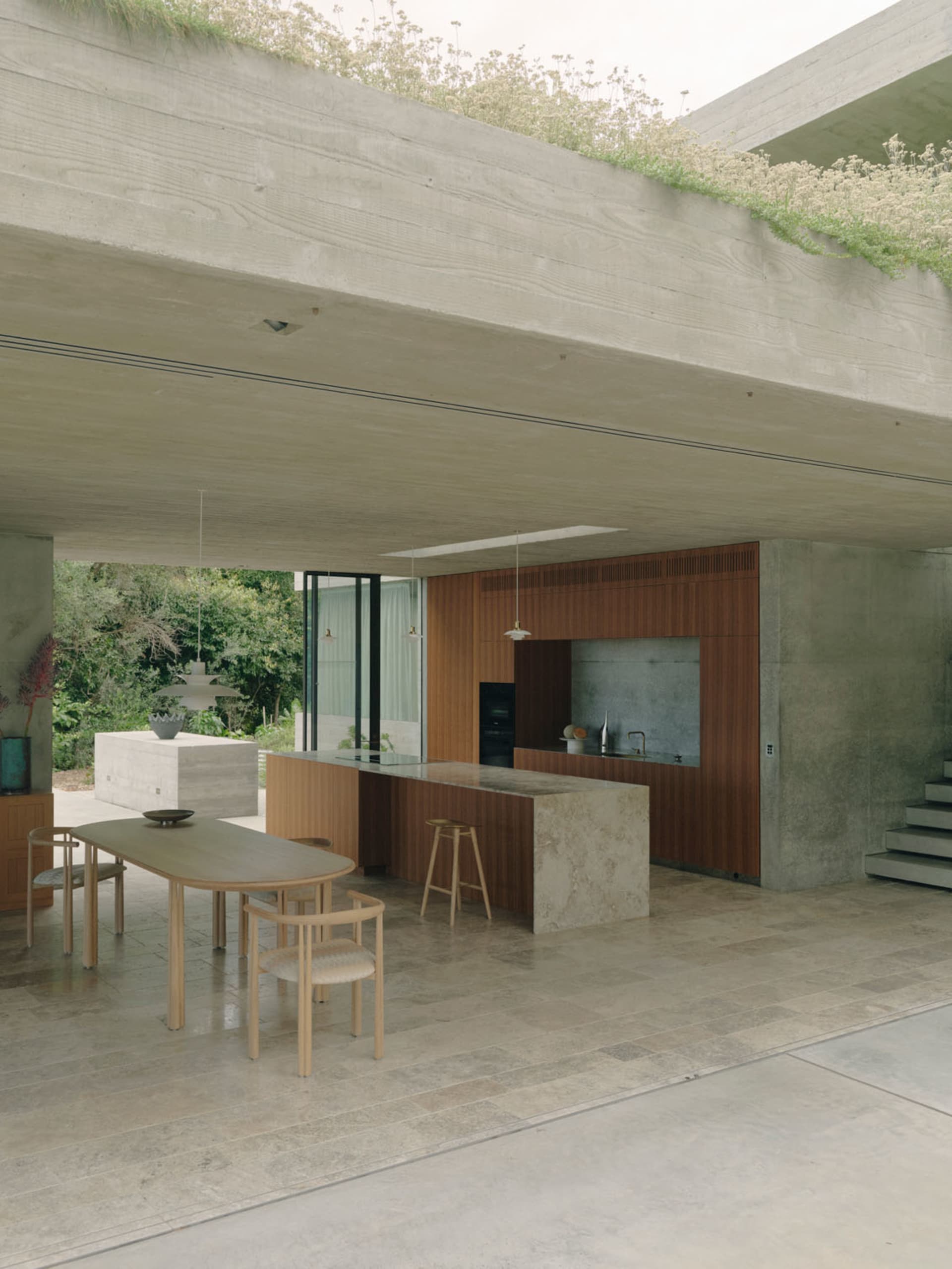 A modern kitchen with concrete and marble materials.