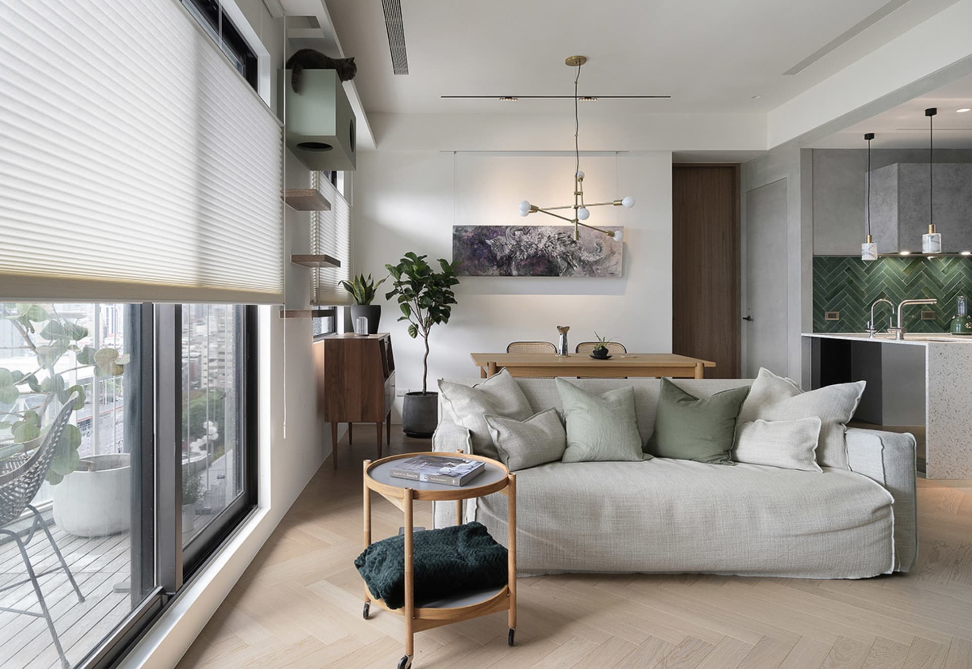 Modern minimalist living room with neutral-toned fabrics, wood, concrete, and green plants.
