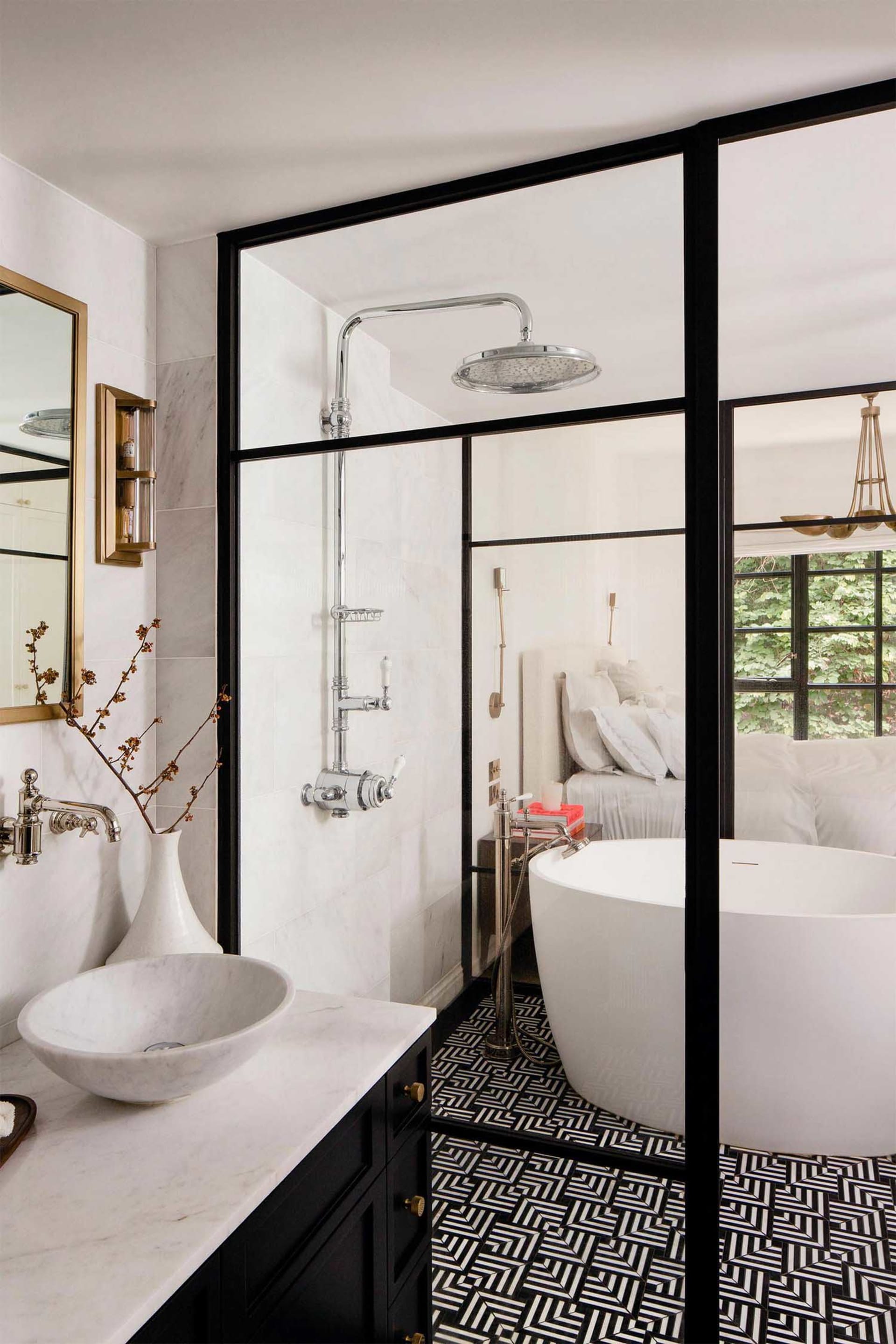 Modern bathroom with a white marble sink, black and white geometric floor tiles, and a white bathtub.